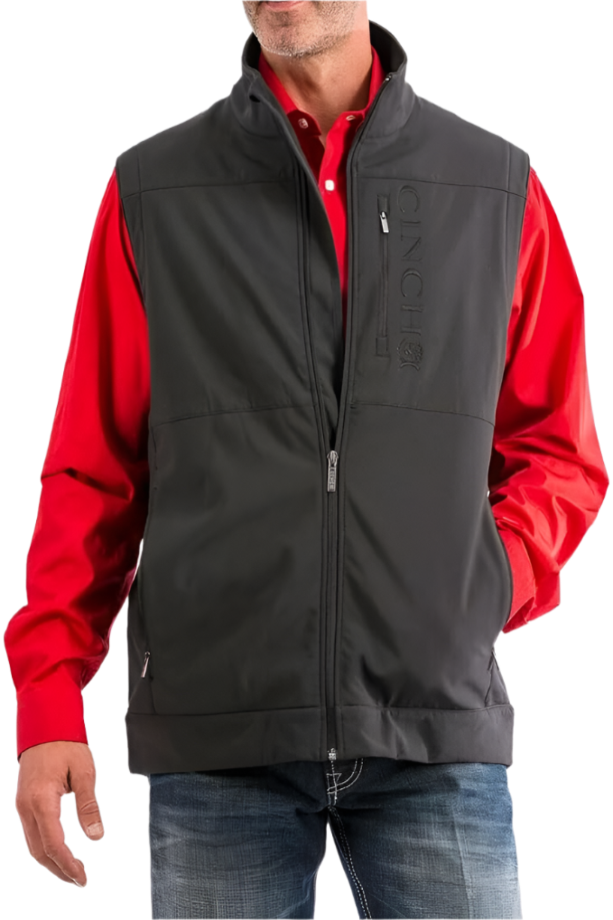 Man wearing a black Cinch softshell vest over a red button-down shirt and jeans on a white background