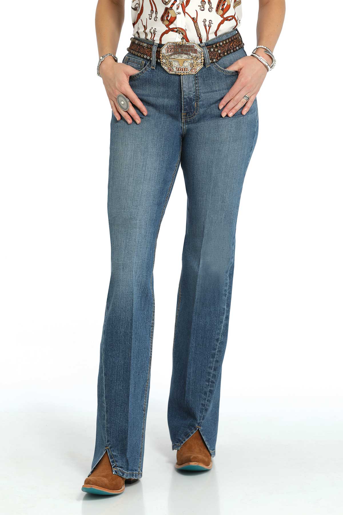 Person wearing blue jeans with a decorative belt on a white background