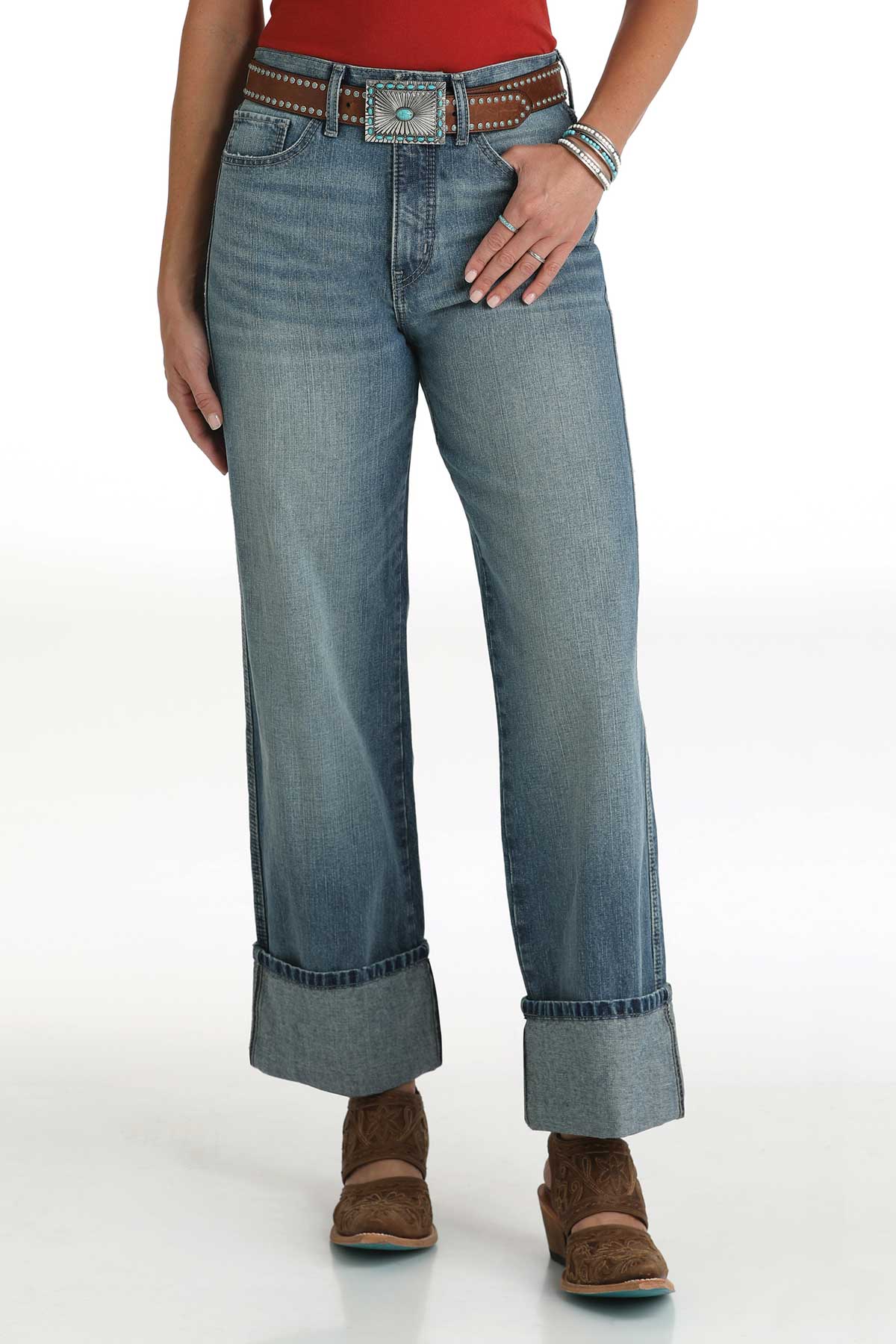 Woman wearing Cruel Ladies light wash high-rise jeans with cuffed hems and a red tucked-in top