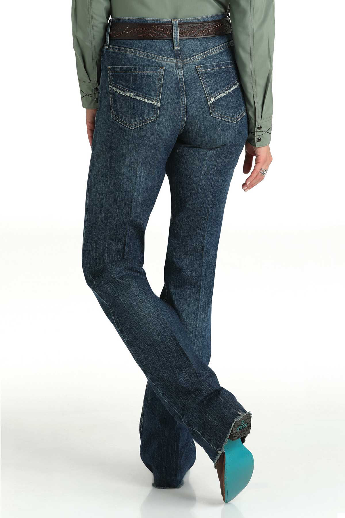 Back view of a woman wearing dark wash bootcut jeans with a belt and cowboy boots