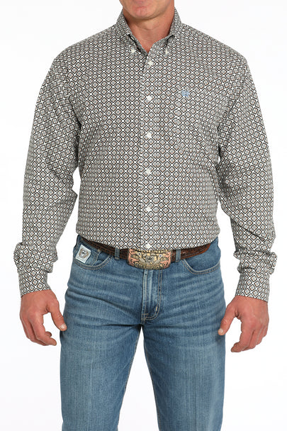 Man wearing a cream geometric print Cinch long sleeve button-down shirt with jeans and a belt buckle on a white background