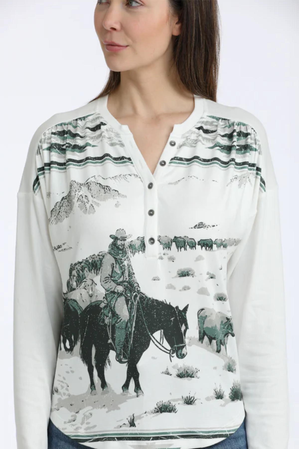 Woman wearing a long-sleeve shirt with a graphic of a cowboy and landscape on a white background