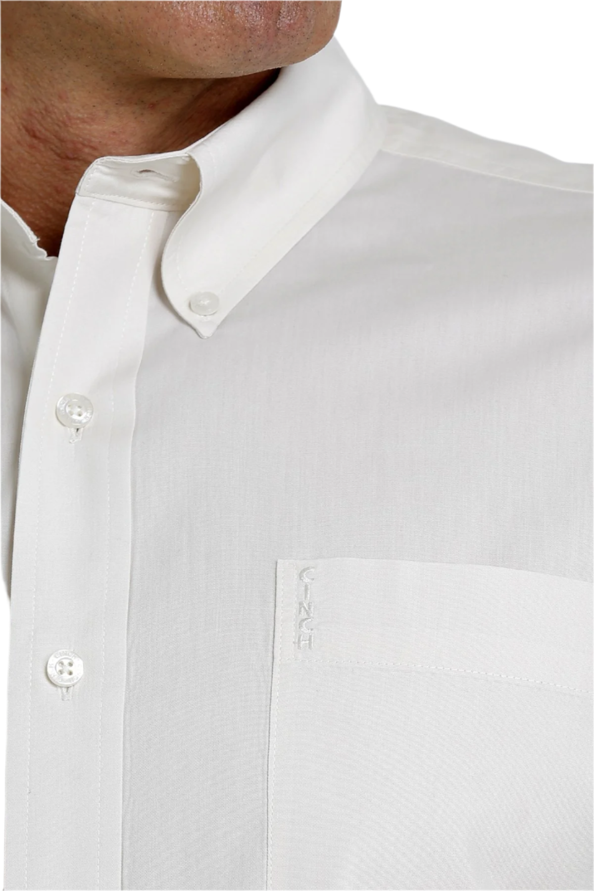 Close-up of a man wearing a cream button-down shirt