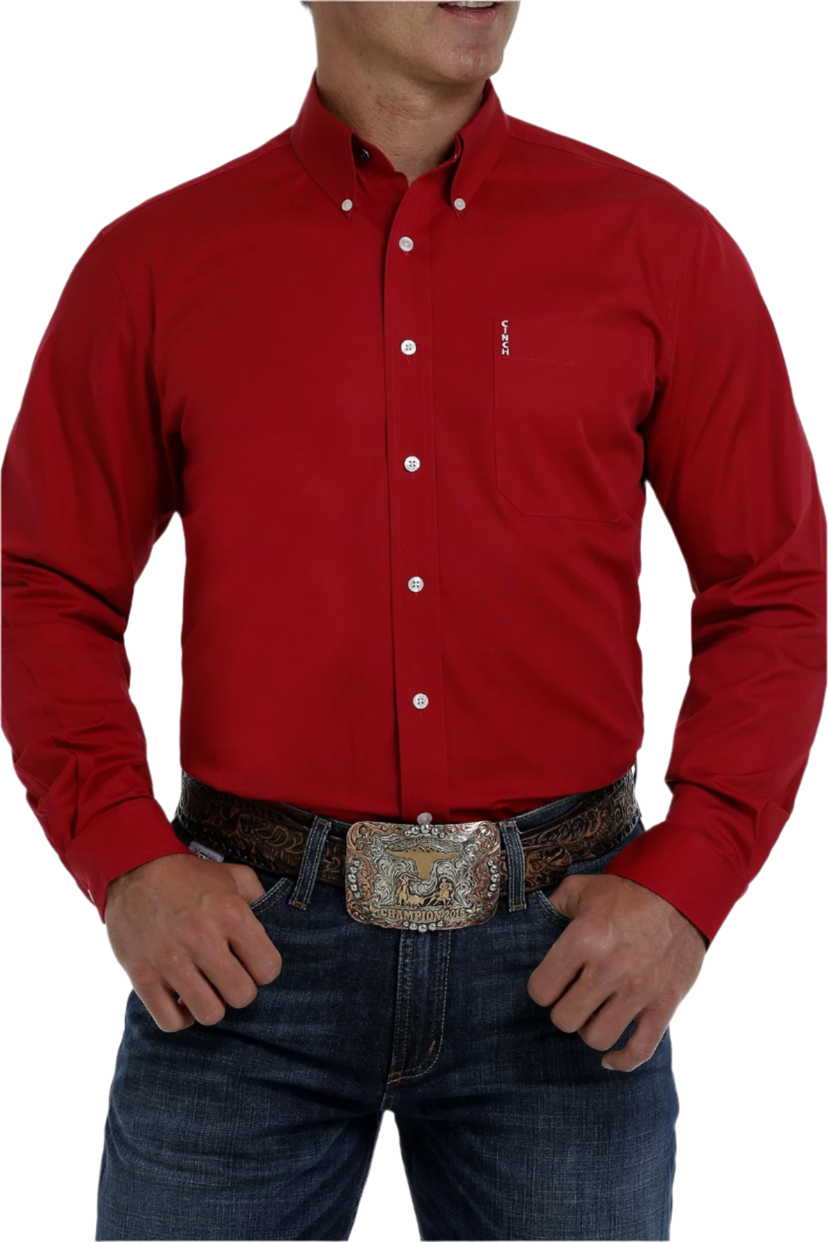 A man wearing a long sleeve red button-down shirt with white buttons and a single chest pocket, paired with blue jeans and a belt with a silver buckle.