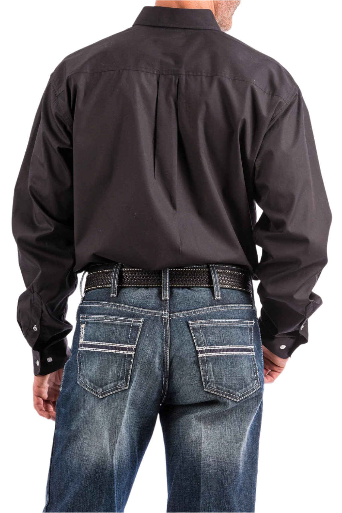 Back view of a man wearing a long sleeve black western shirt and blue jeans, with a belt