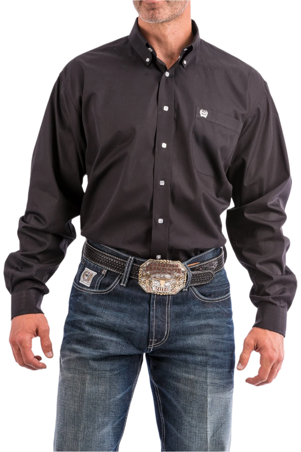 A man wearing a long sleeve black western shirt and blue jeans, with a belt and buckle visible.