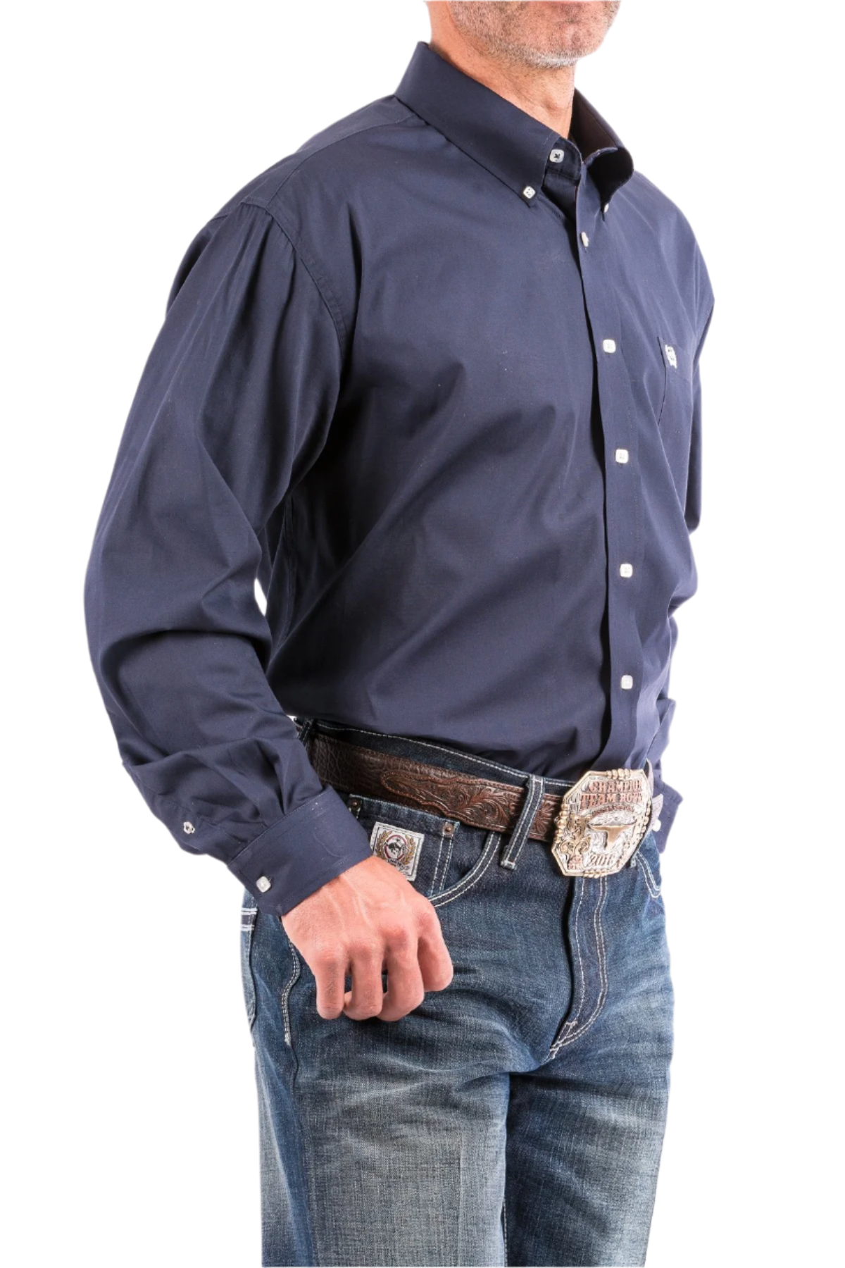 A man wearing a navy long sleeve button-down shirt and blue jeans, with a belt and buckle visible.