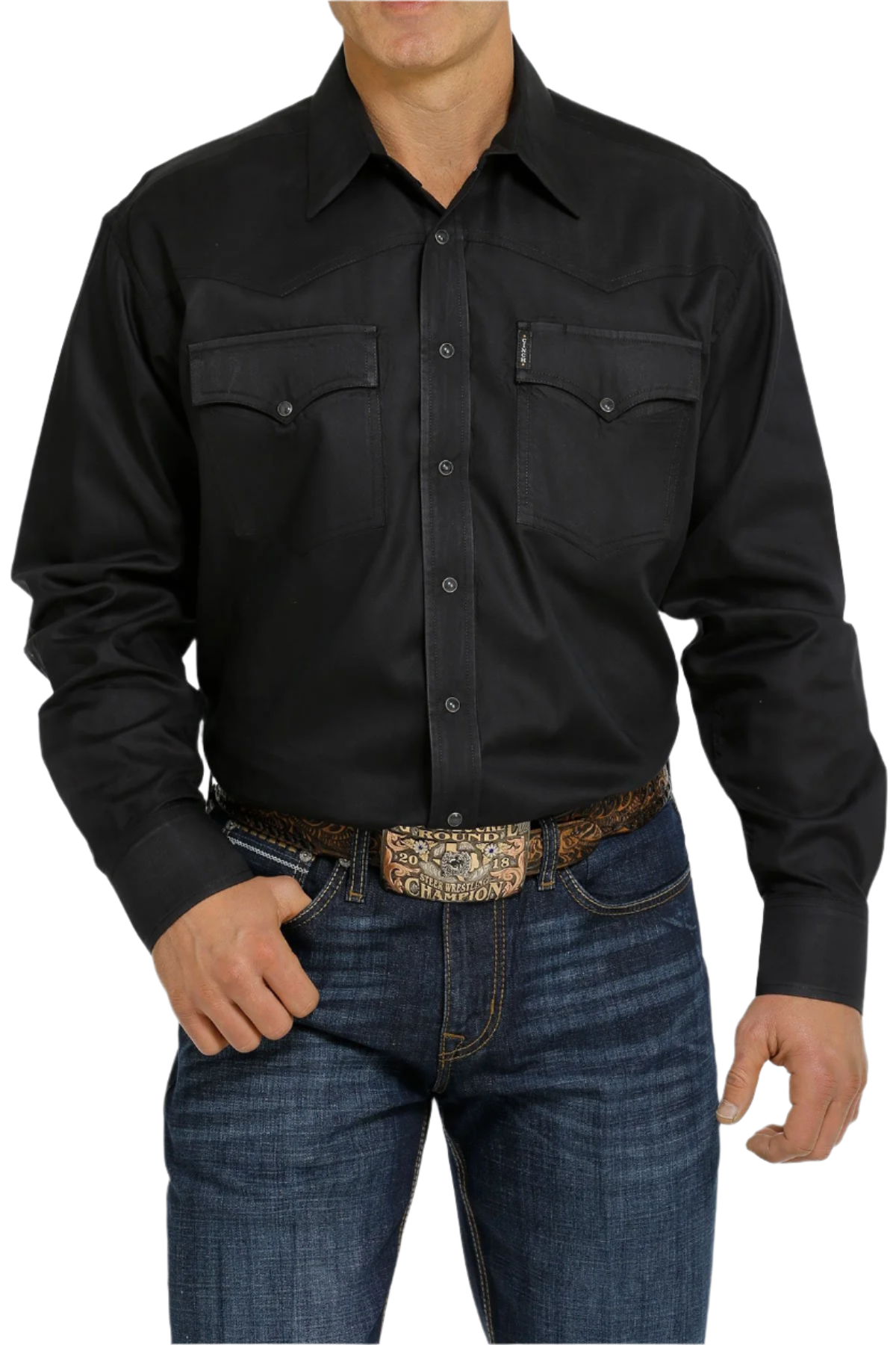 A man wearing a long-sleeve black Western snap shirt with double pockets and front western yoke, paired with blue jeans.
