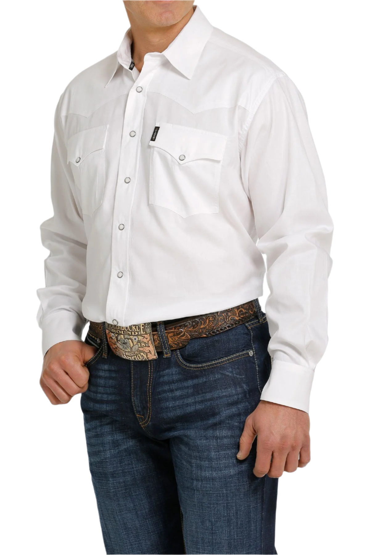 A man wearing a long-sleeve white Western snap shirt with double pockets and front western yoke, paired with blue jeans.