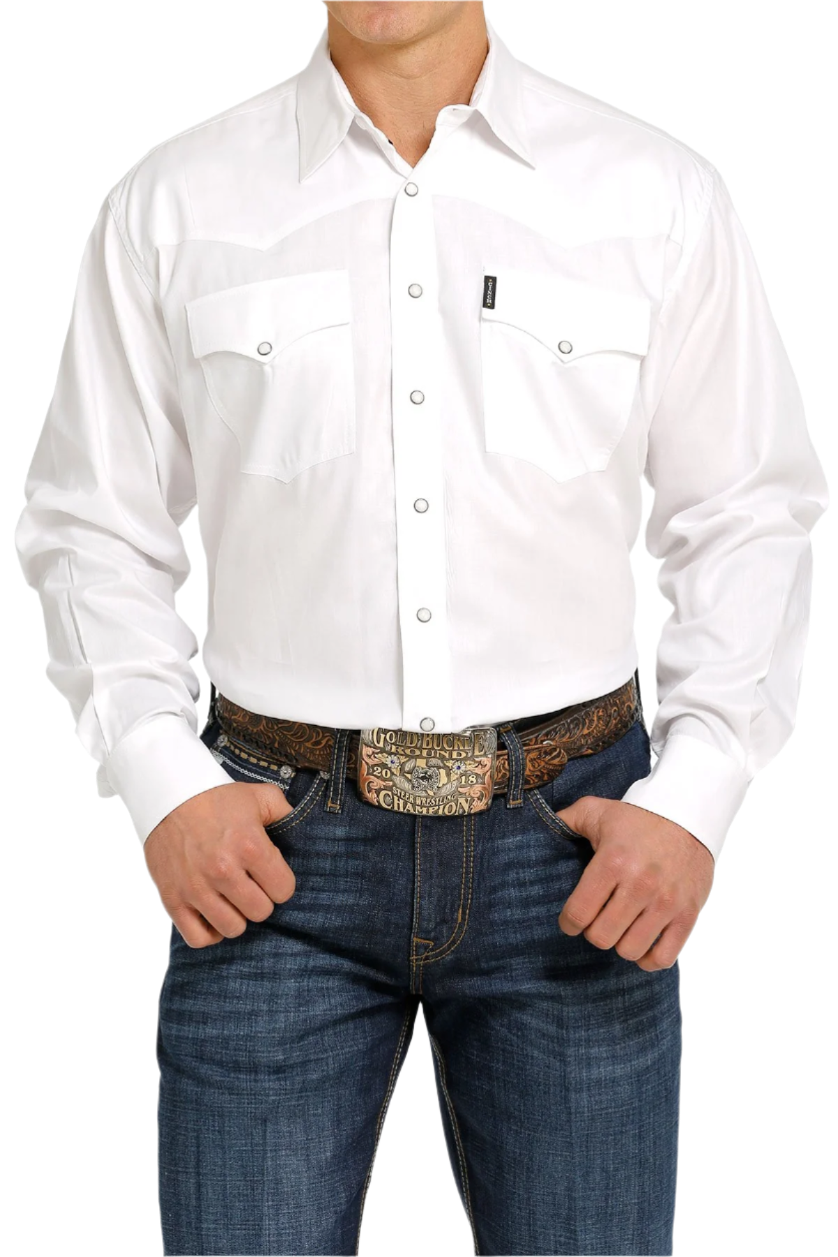A man wearing a long-sleeve white Western snap shirt with double pockets and front western yoke, paired with blue jeans.