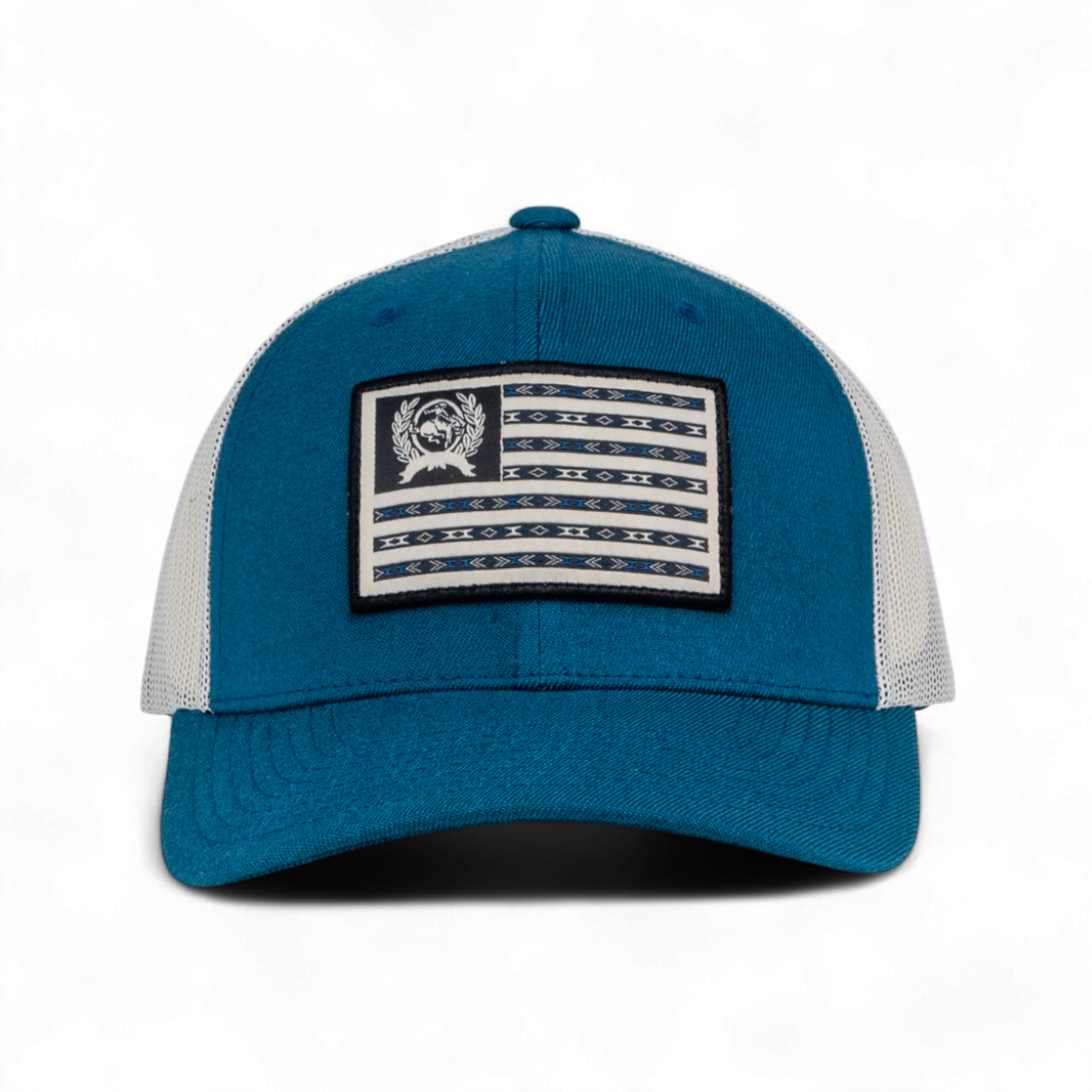 Teal and white trucker hat with a curved brim and mesh back. The front features a rectangular patch with a flag-inspired design and a circular emblem in the corner