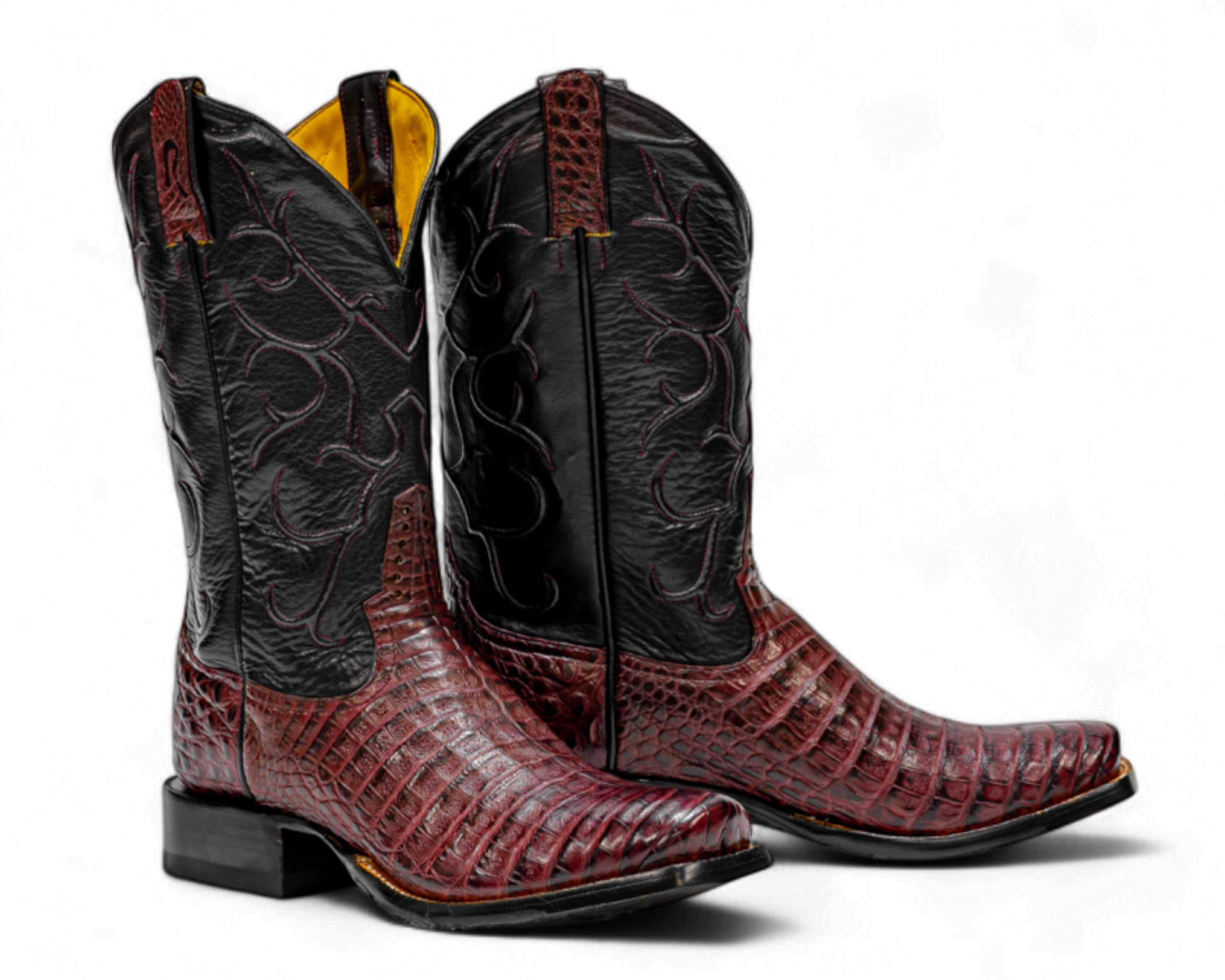Pair of cowboy boots with black and red design on a white background