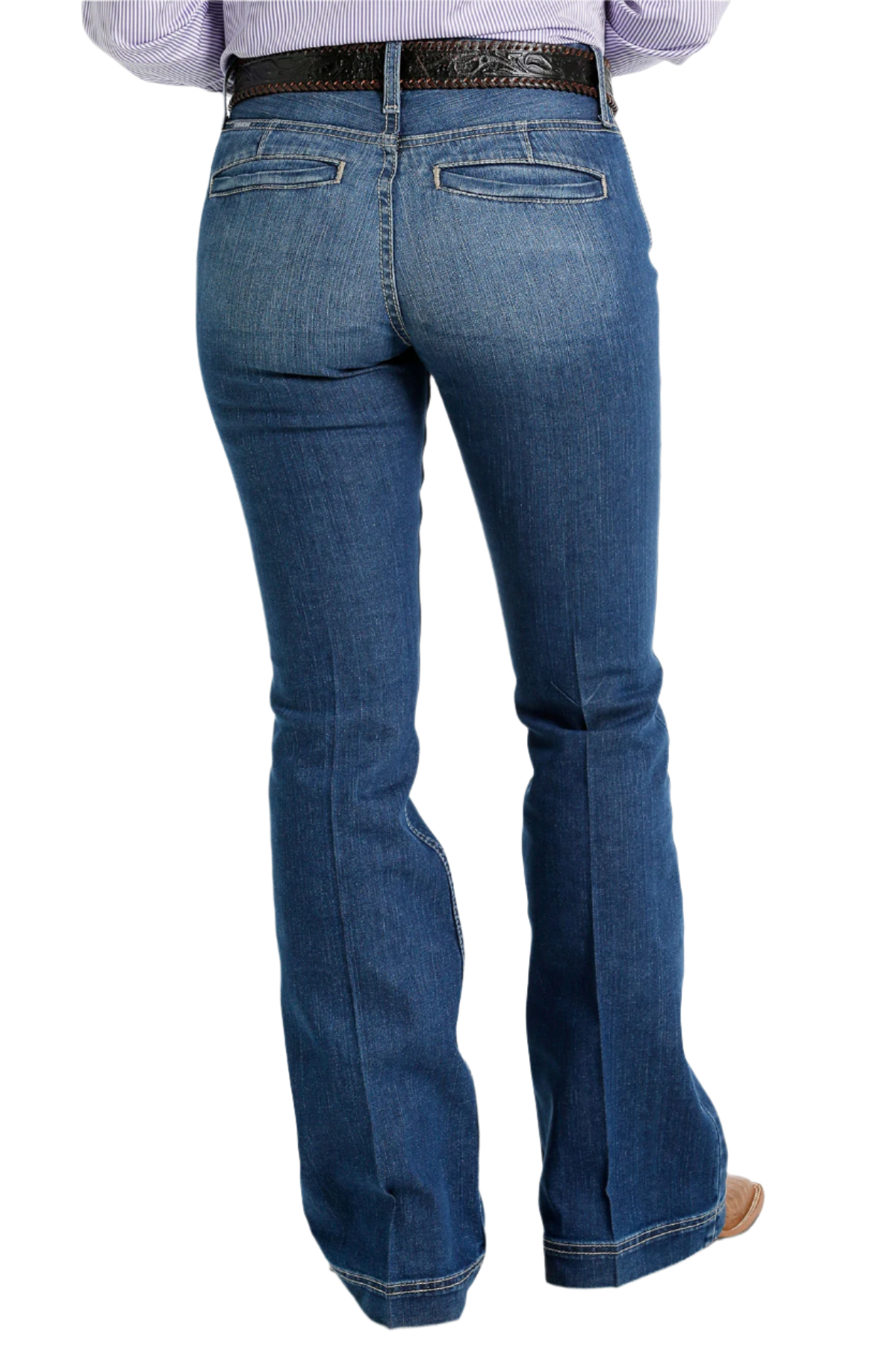 Back view of a pair of Cinch ladies slim trouser jeans in a medium stonewash color, including a belt and shoes.