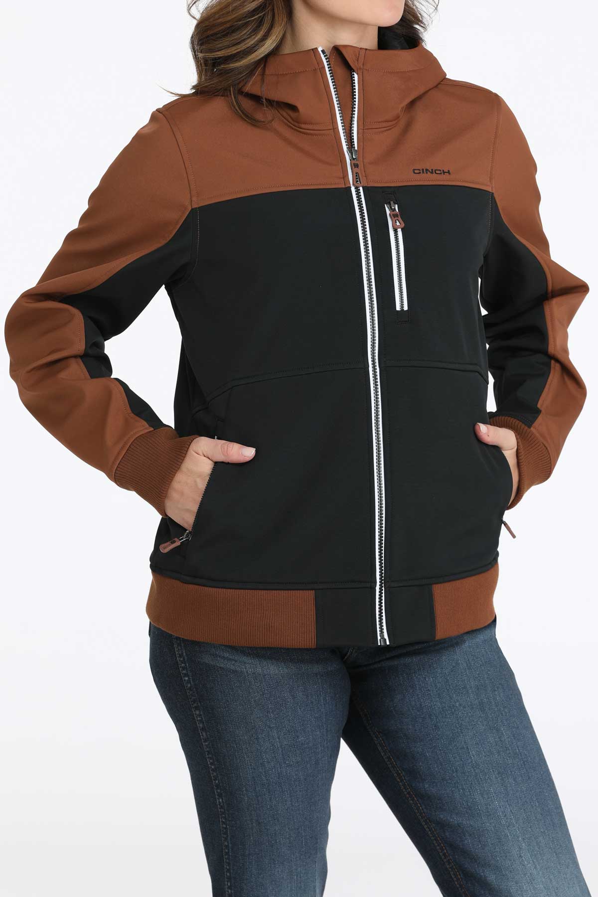 Woman wearing a two-toned black and brown jacket with jeans