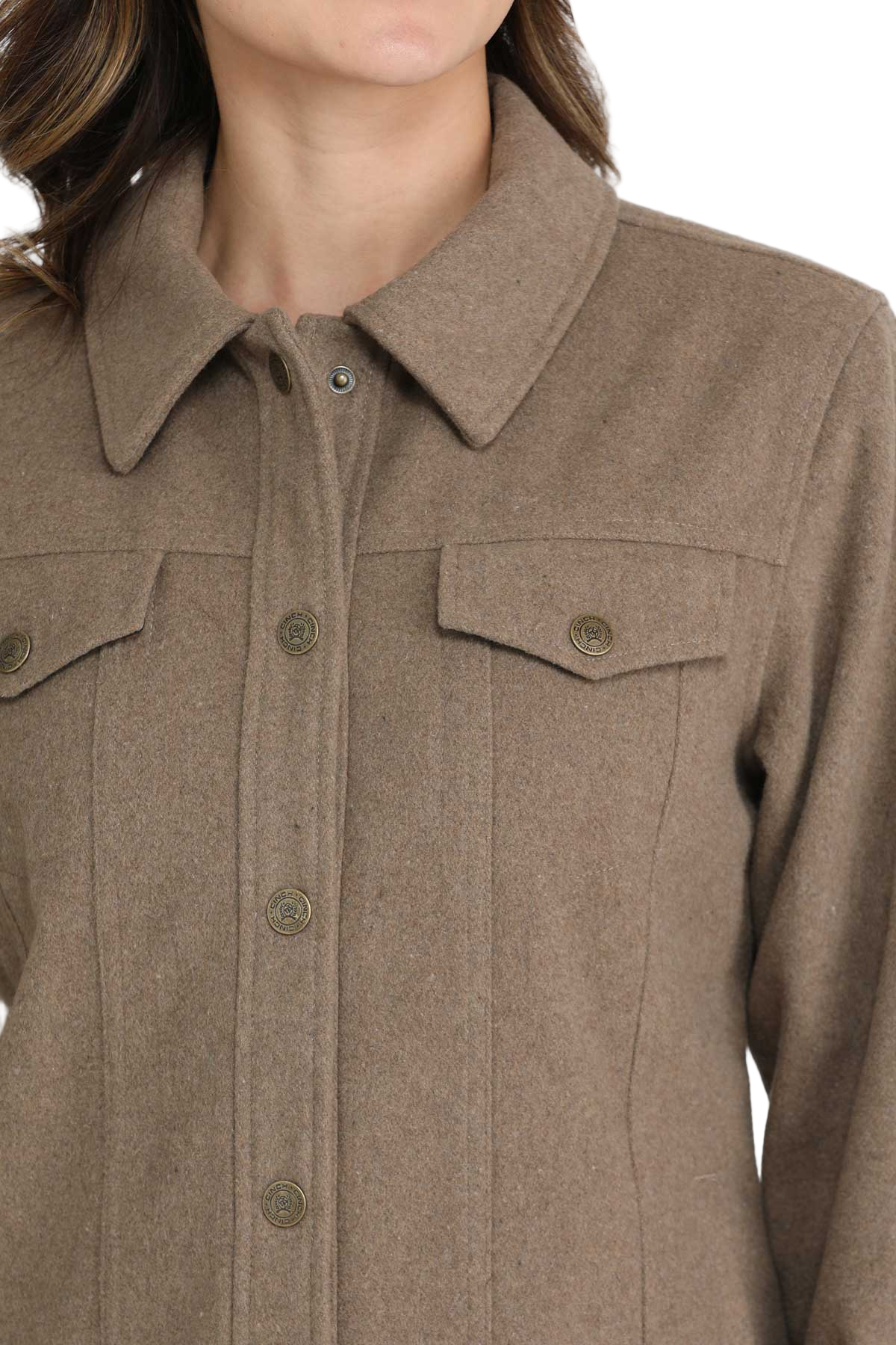 Close-up of a woman wearing a taupe button-up jacket with flap chest pockets and long sleeves