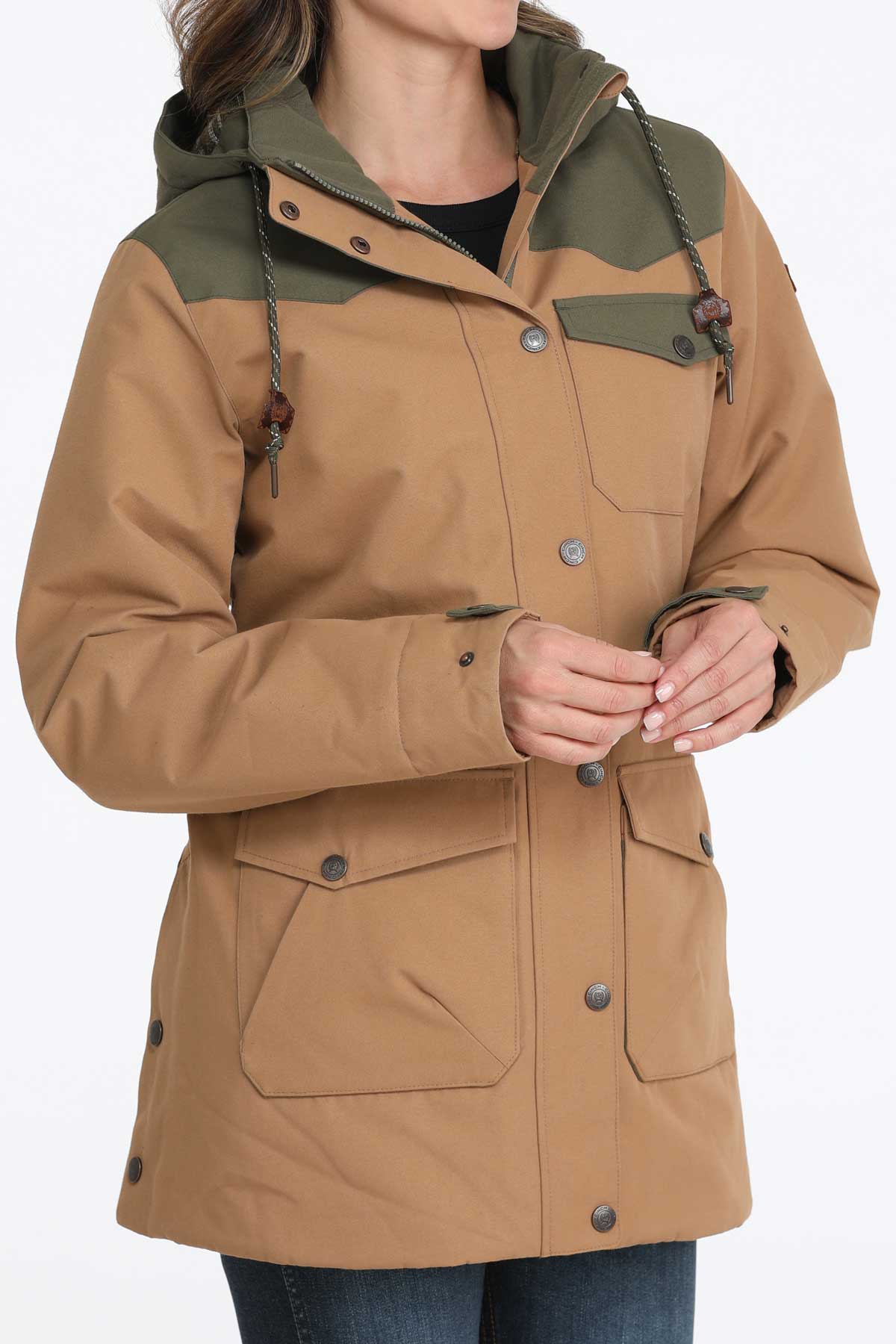Woman wearing a brown jacket with green accents and jeans