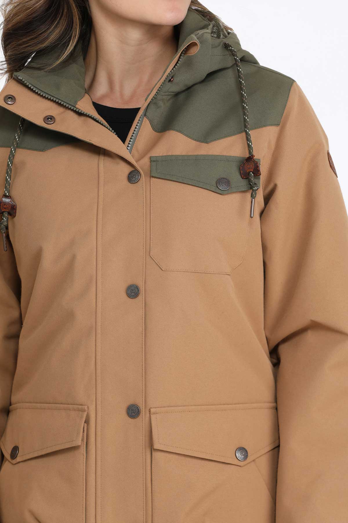 Close-up of a woman wearing a brown jacket with green accents