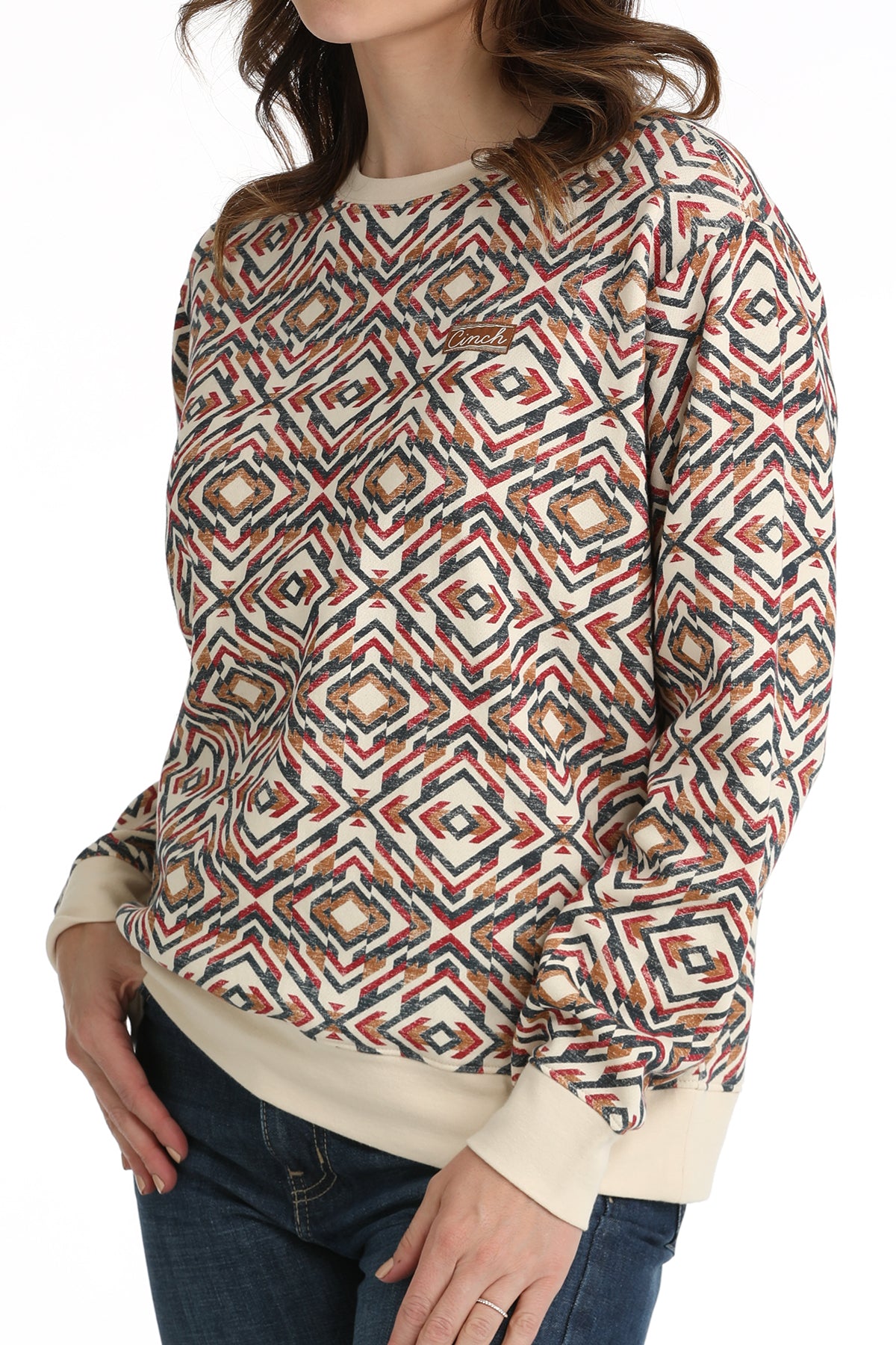 Woman wearing a patterned sweater with geometric design on a white background