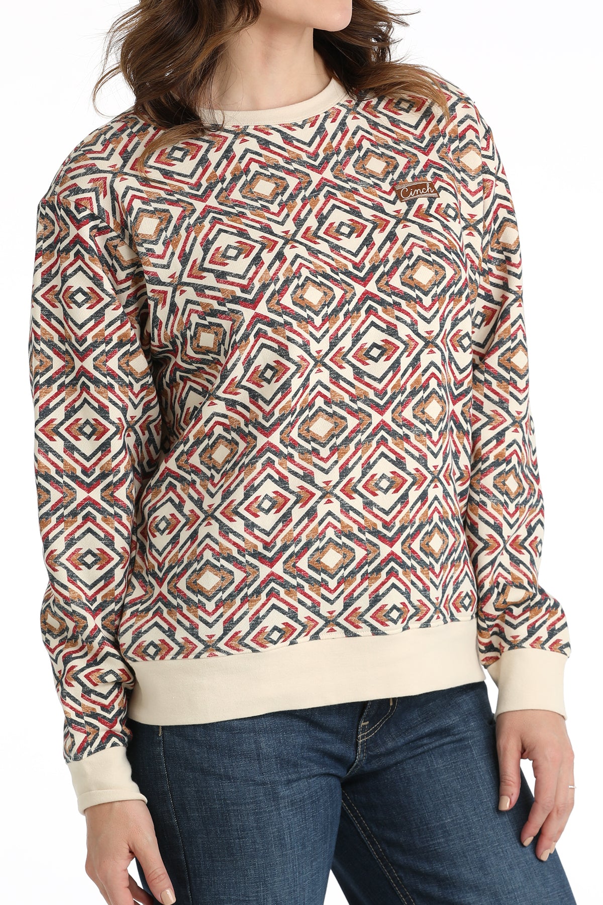 Person wearing a patterned sweater and jeans on a white background