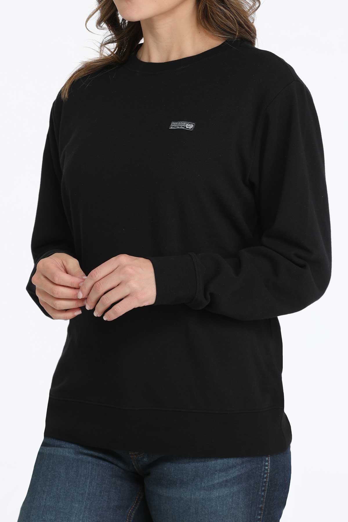 Person wearing a black sweatshirt with a logo on a white background