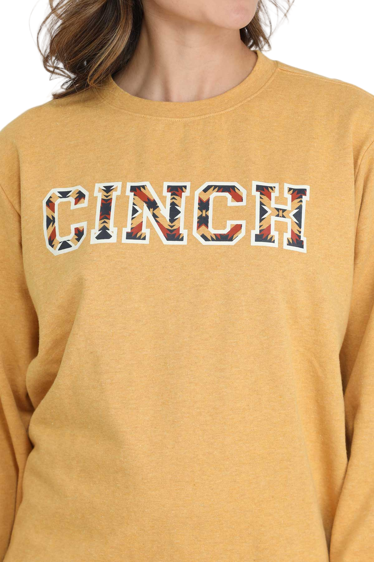 Woman wearing a yellow crewneck sweatshirt with patterned CINCH lettering