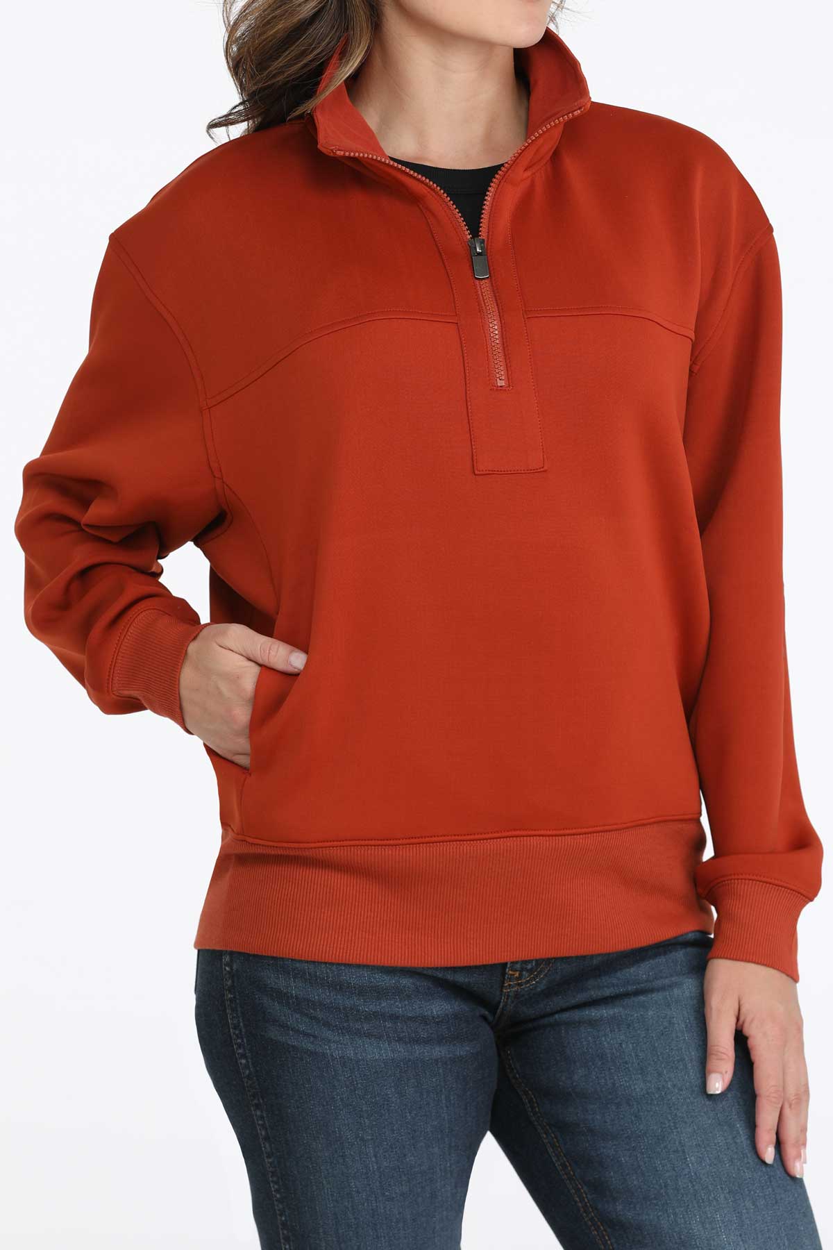 Woman wearing a Cinch ladies’ red quarter-zip sweatshirt with jeans on a white background