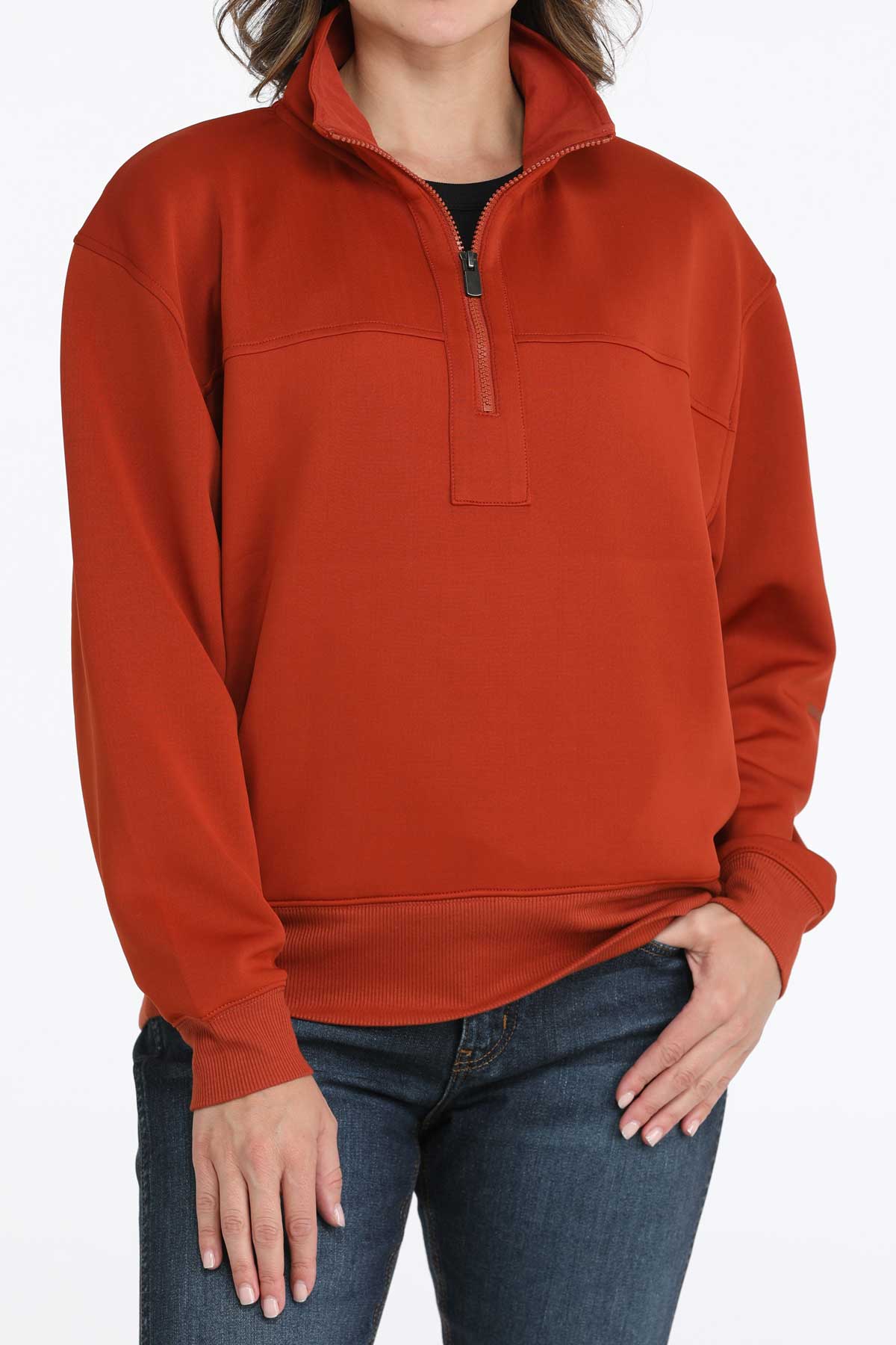Woman wearing a Cinch ladies’ red quarter-zip sweatshirt with jeans on a white background