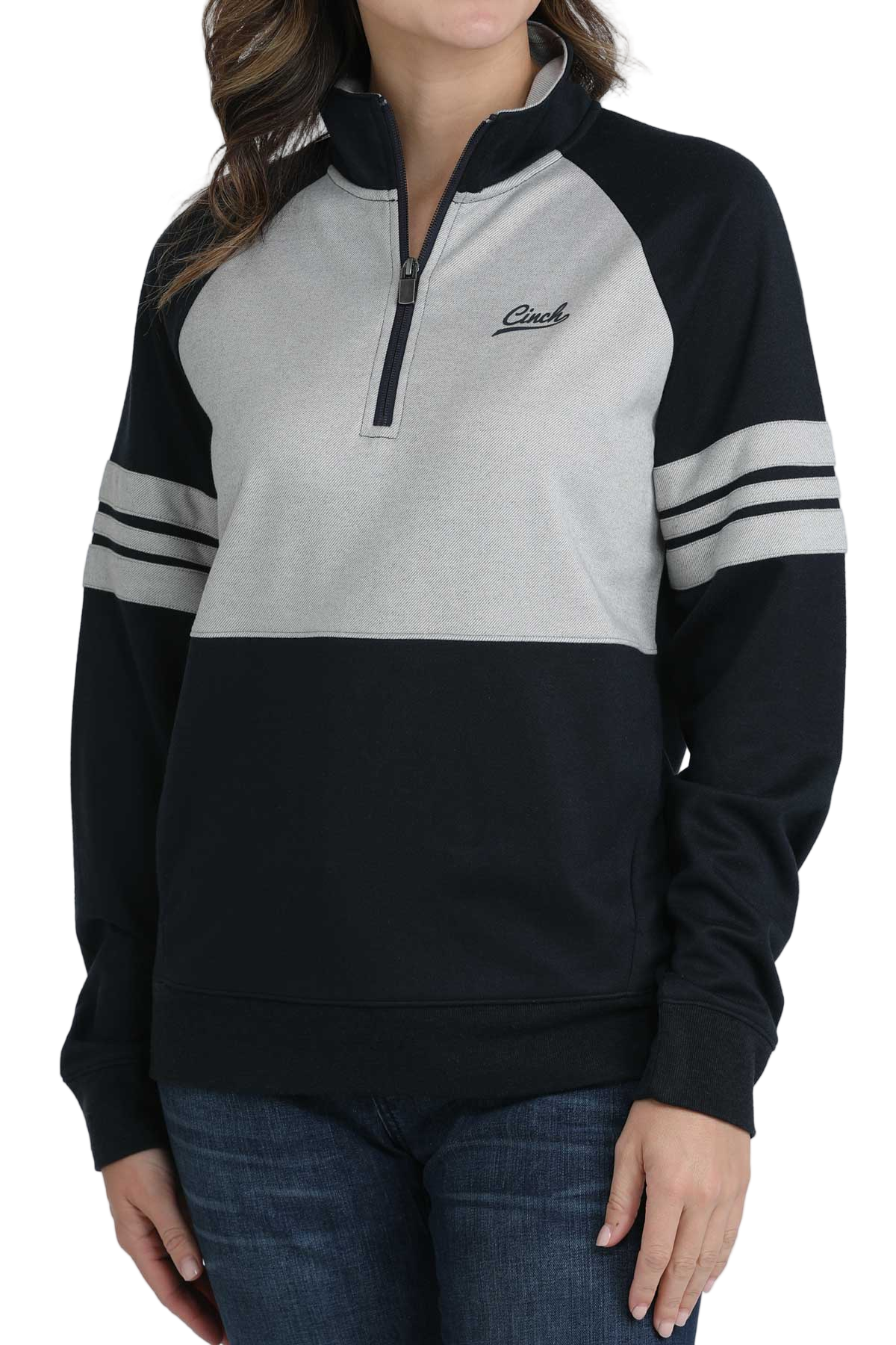 Woman wearing a black and heather-gray quarter-zip pullover with striped sleeves and dark jeans