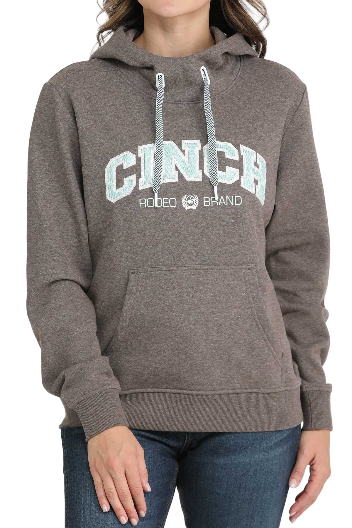 Woman wearing a brown CINCH hoodie with blue drawstrings and a front kangaroo pocket, paired with blue jeans