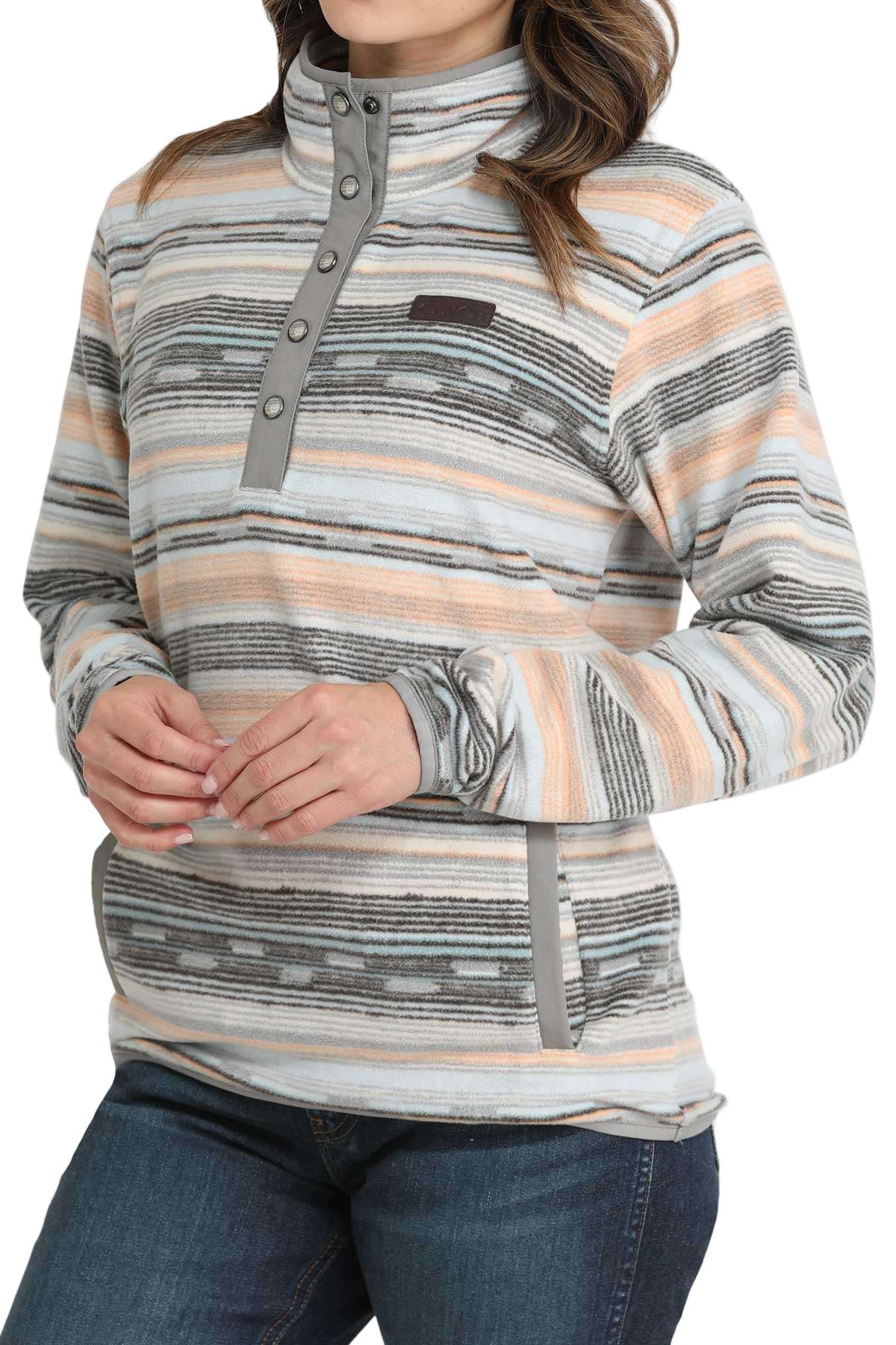 Woman wearing a striped fleece pullover with a snap-up mock neck and front pockets, paired with dark denim jeans