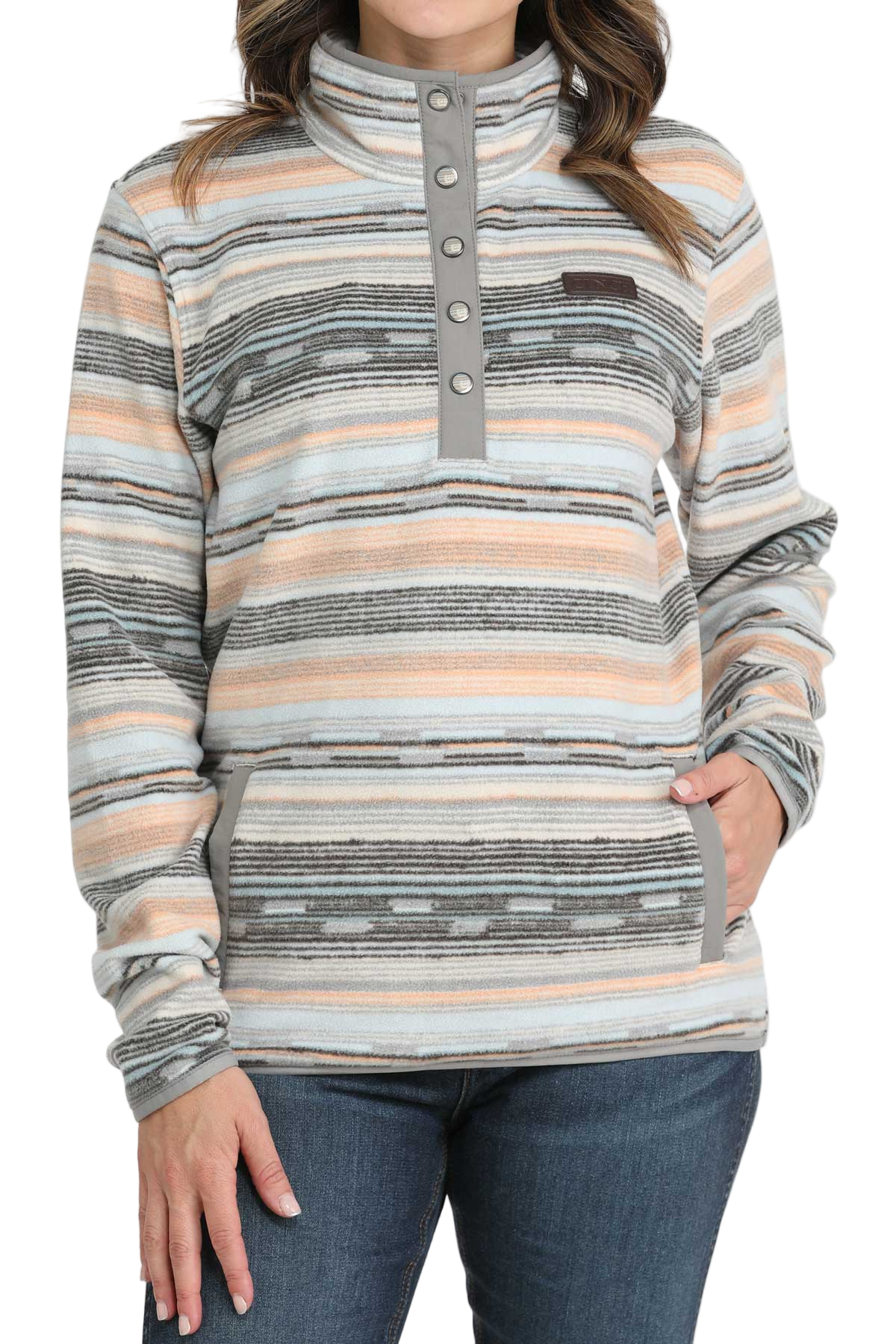 Woman wearing a striped fleece pullover with a snap-up mock neck and front pockets, paired with dark denim jeans