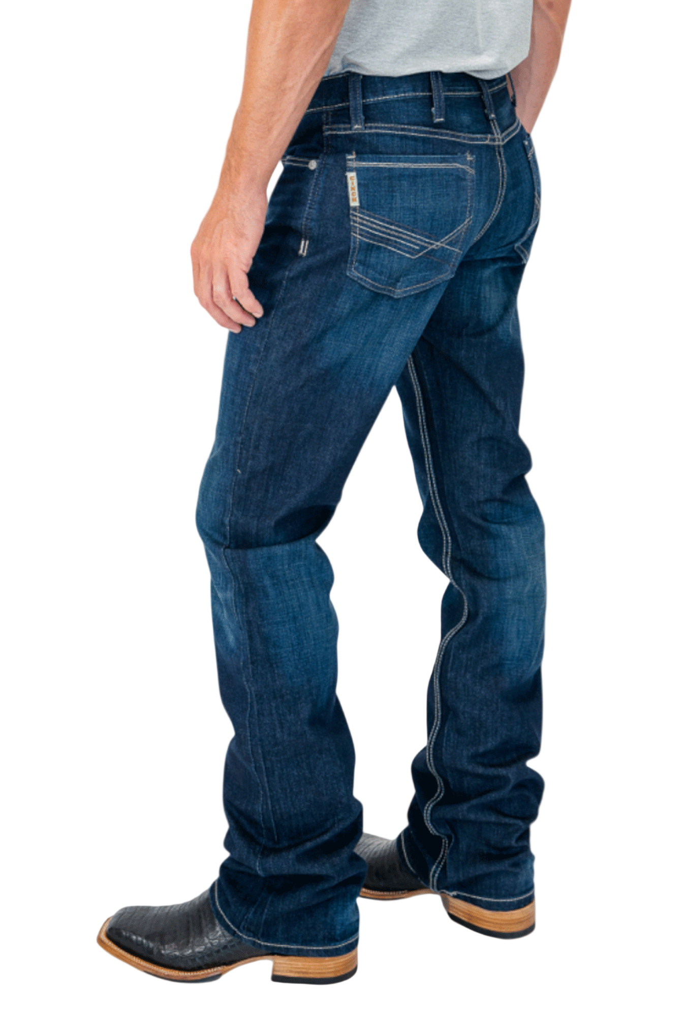 Person wearing blue jeans and black boots on a white background