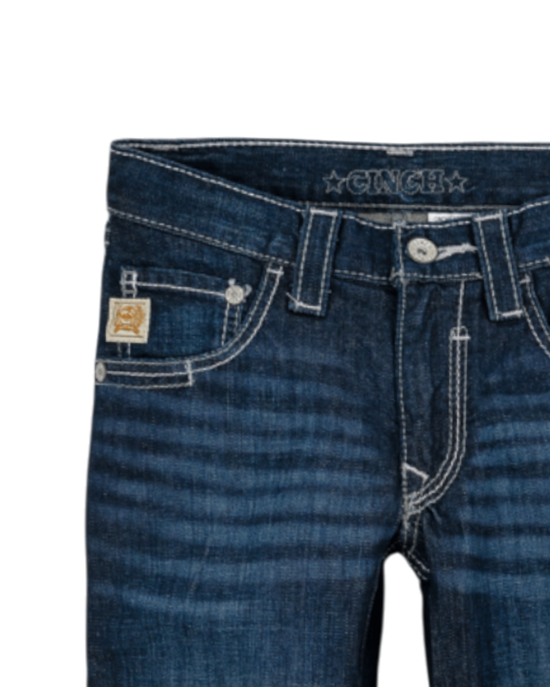Close-up of the front of dark blue denim jeans with light fading, featuring a coin pocket with a small embroidered patch, belt loops, and a button closure with a zipper fly. The waistband has 'CINCH' stitched on it