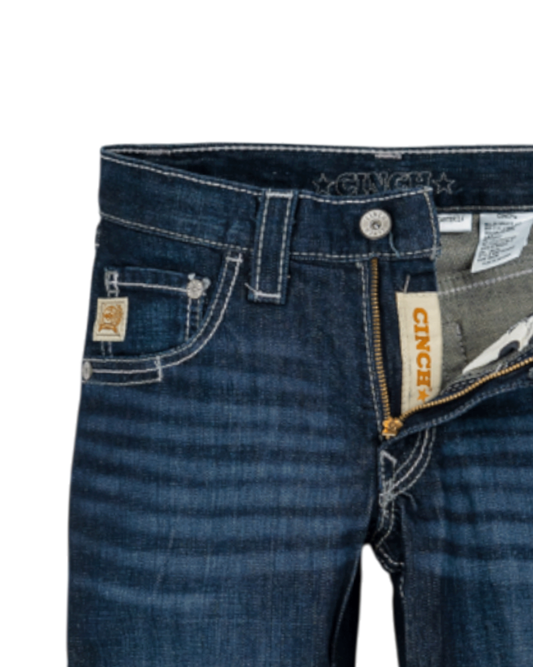Close-up of the front of dark blue denim jeans with light fading, featuring a coin pocket with a small embroidered patch, belt loops, and a button closure with a zipper fly. The waistband has 'CINCH' stitched on it