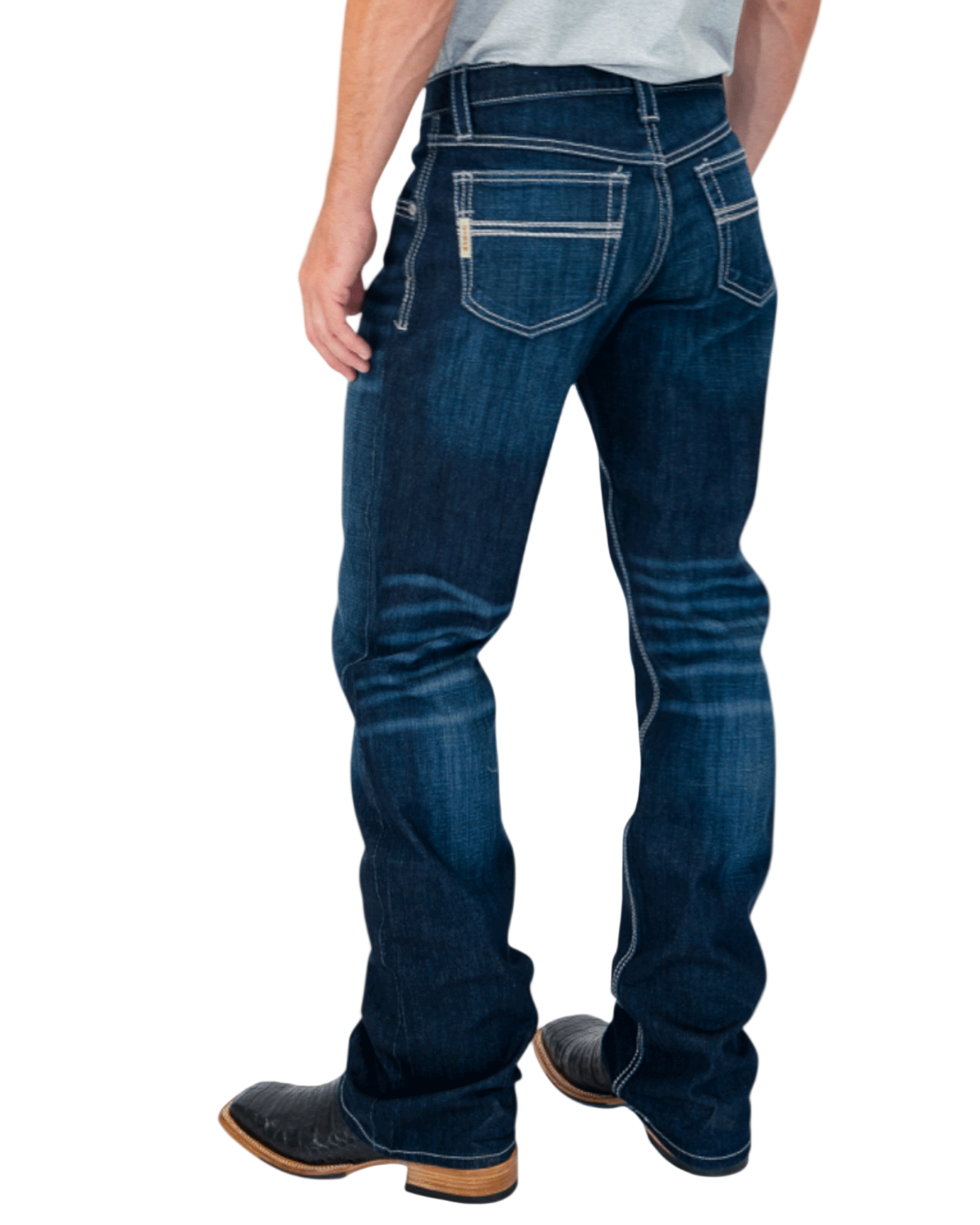 Person wearing blue jeans and black boots on a white background