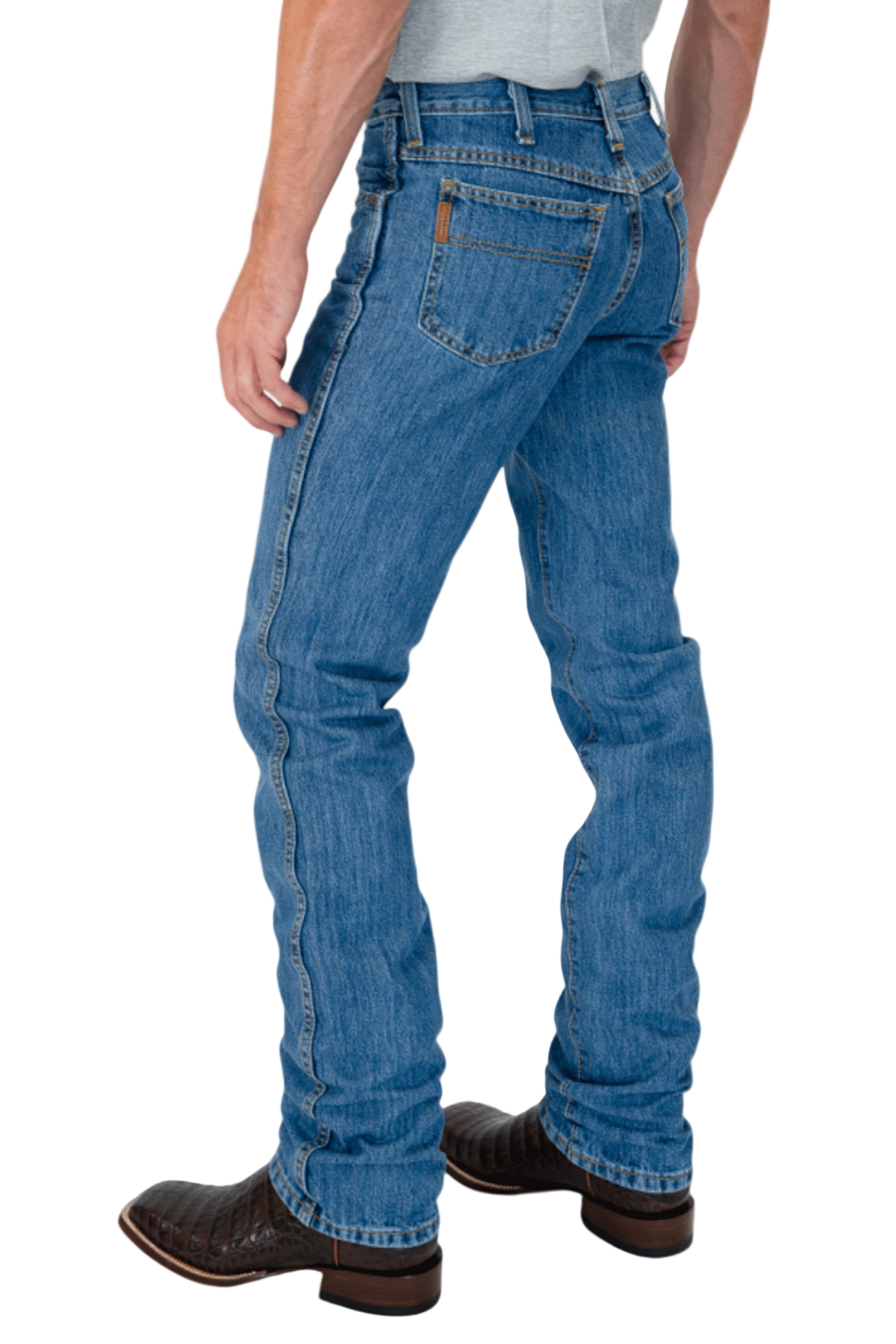 Person wearing blue jeans and brown boots on a white background