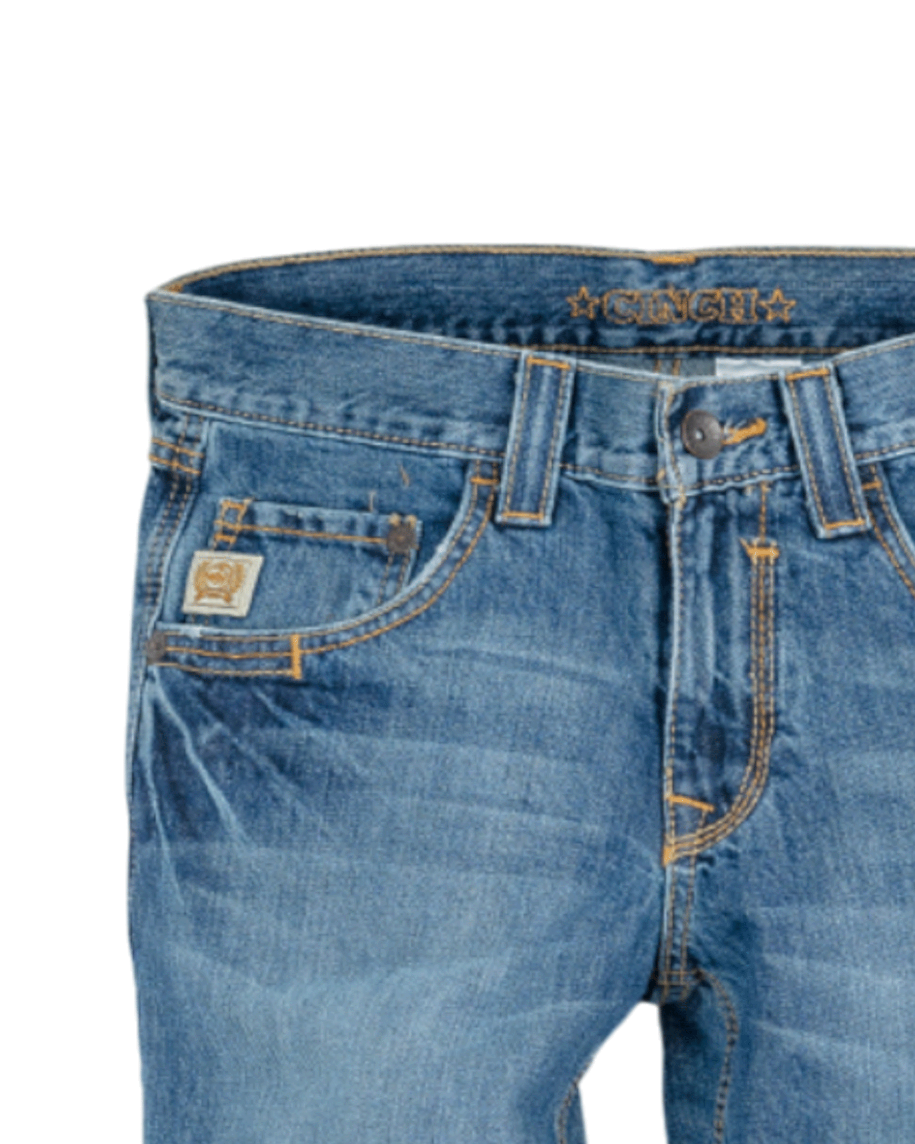 Close-up of the front of blue denim jeans with light fading, featuring a coin pocket with a small embroidered patch, belt loops, and a button closure with a zipper fly. The waistband has 'CINCH' stitched in gold thread