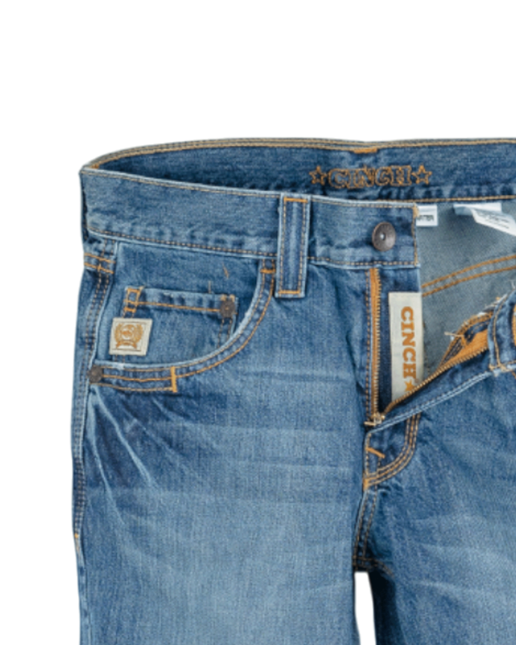 Close-up of the front of blue denim jeans with light fading, featuring a coin pocket with a small embroidered patch, belt loops, and a button closure with a zipper fly. The waistband has 'CINCH' stitched in gold thread