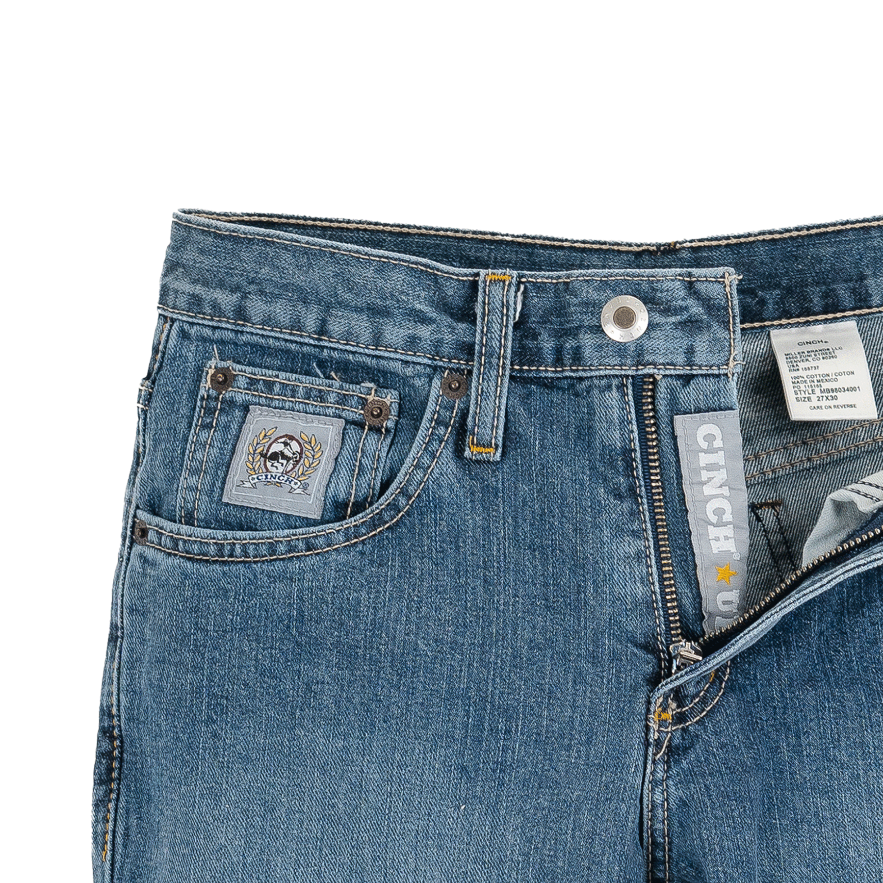 A pair of medium wash denim jeans with a partially unzipped fly, showcasing a Cinch logo on the inner waistband and a stitched patch above the coin pocket.