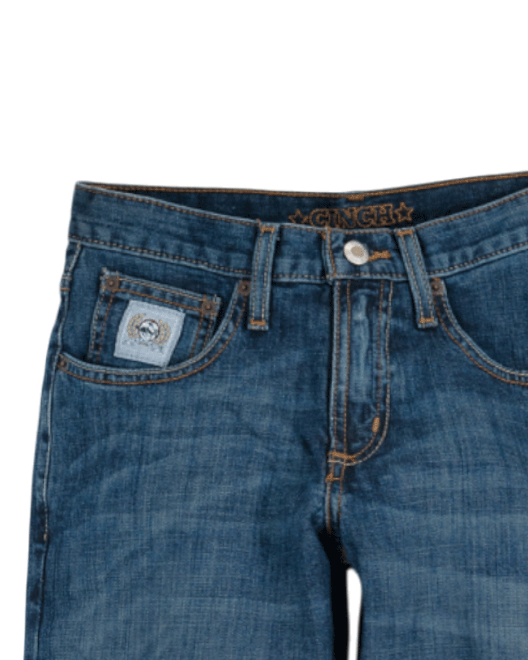 Close-up of the front of blue denim jeans with light fading, featuring a coin pocket with a small embroidered patch, belt loops, and a button closure with a zipper fly. The waistband has 'CINCH' stitched in gold thread