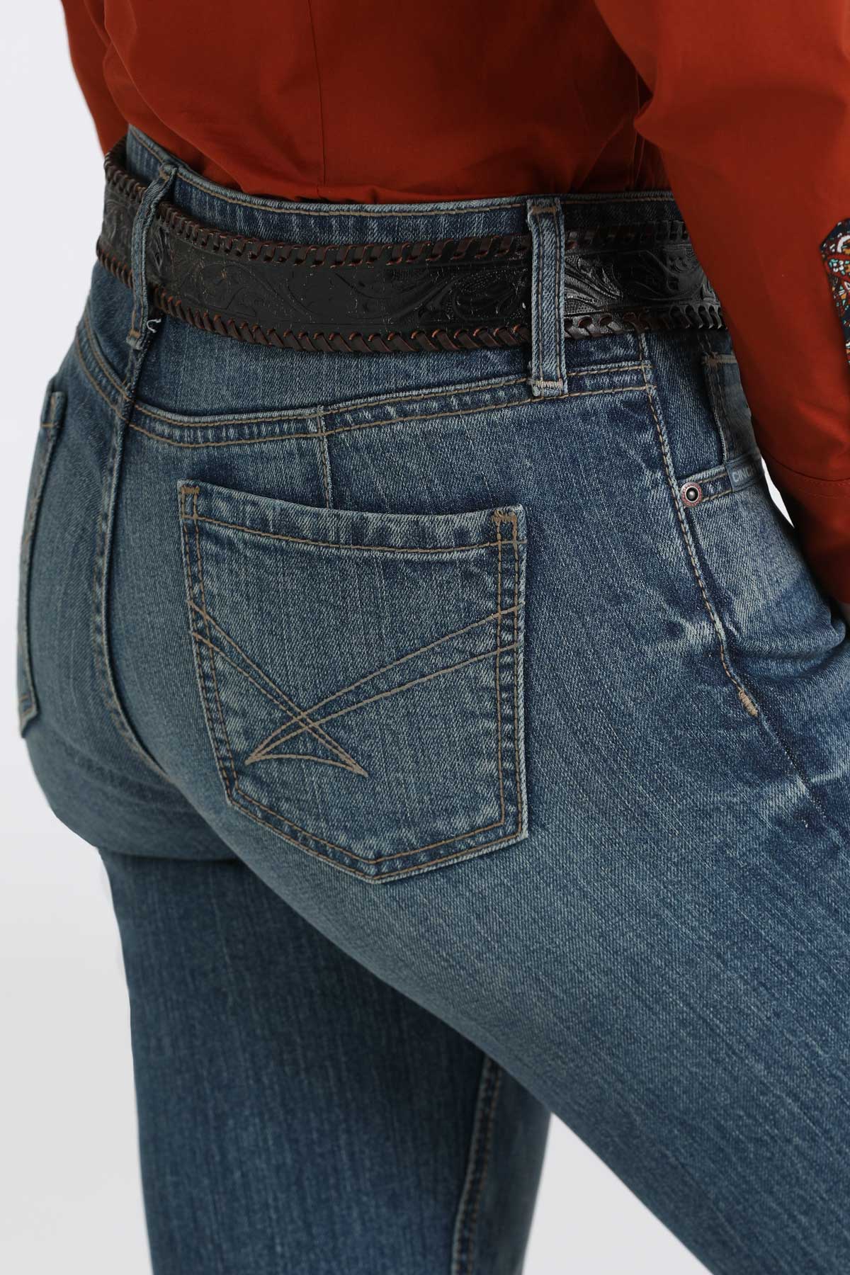 Close-up, back-view of women's medium washed blue jeans paired with a red shirt and a belt
