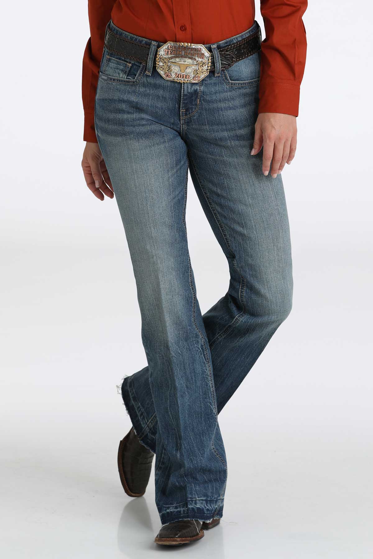 Women's medium washed blue jeans paired with a red shirt, a belt and boots