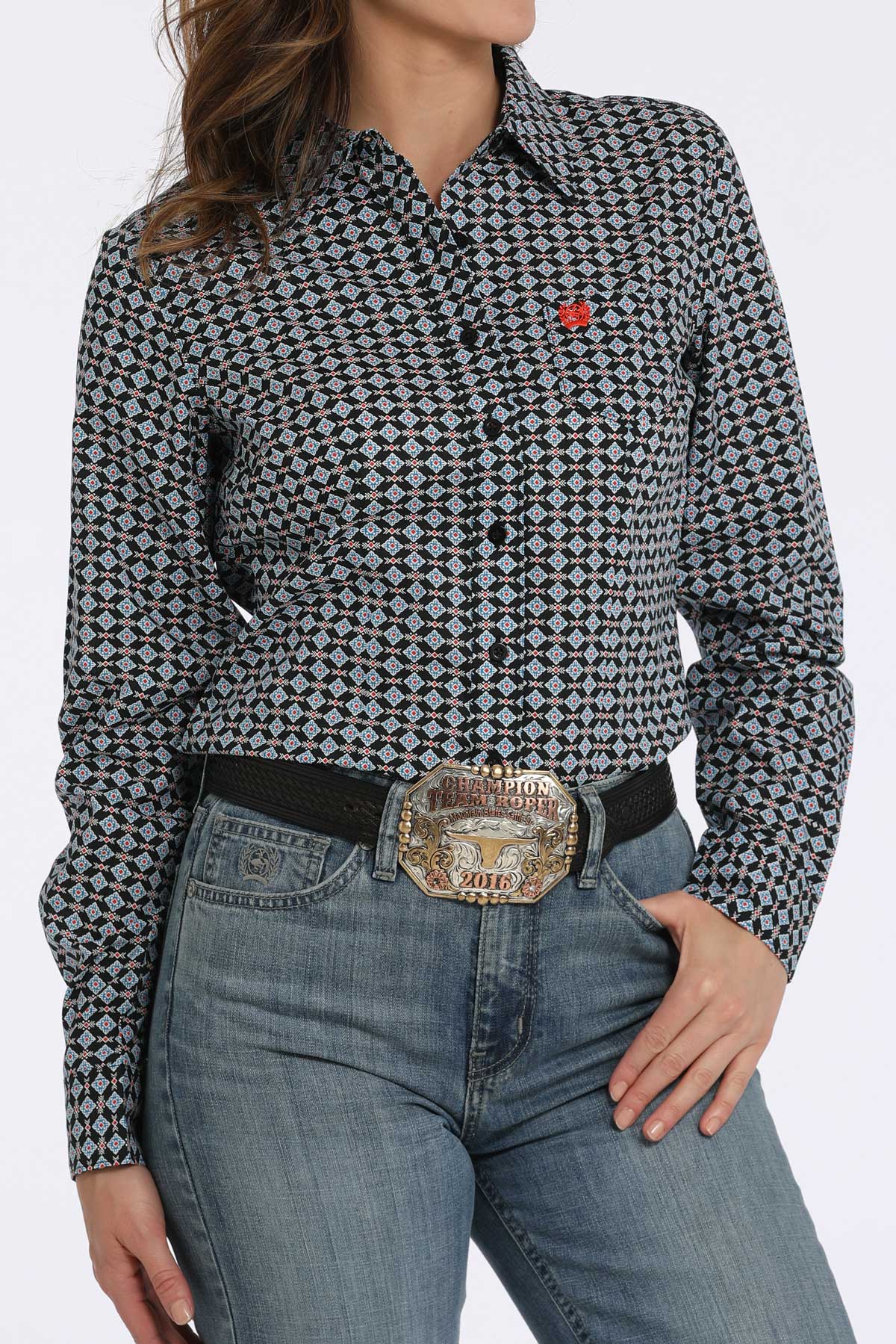 Person wearing a patterned shirt and jeans with a belt buckle.