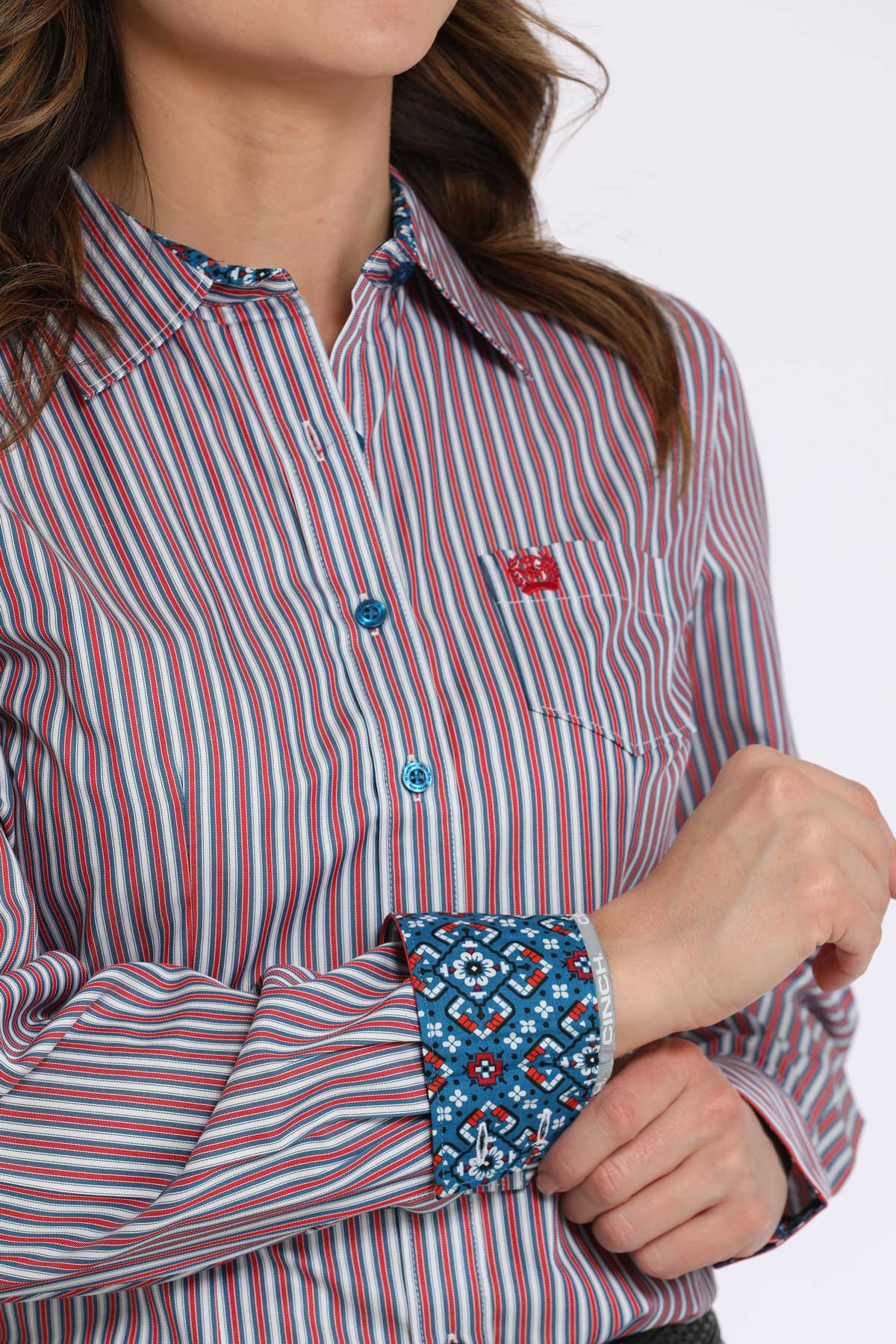 Red and white striped shirt with patterned cuffs on a plain background