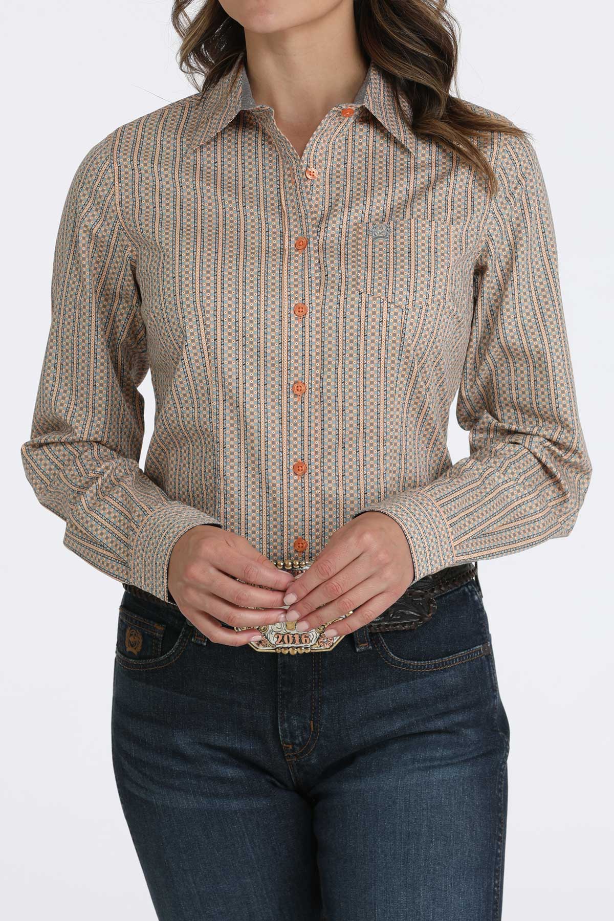 Woman wearing a brown long sleeve button-down with jeans and a belt
