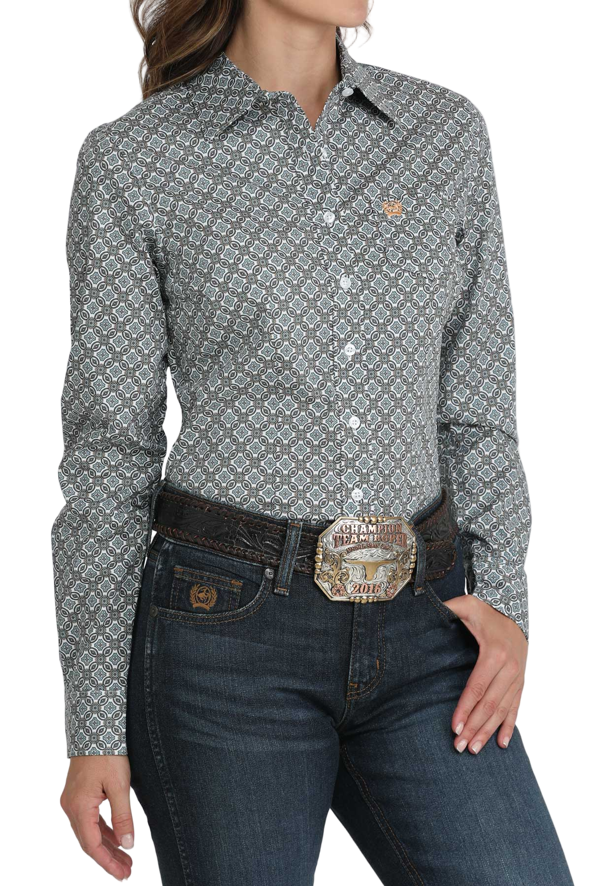 Woman wearing a long-sleeve patterned button shirt paired with dark-wash jeans and a brown belt with a large decorative buckle