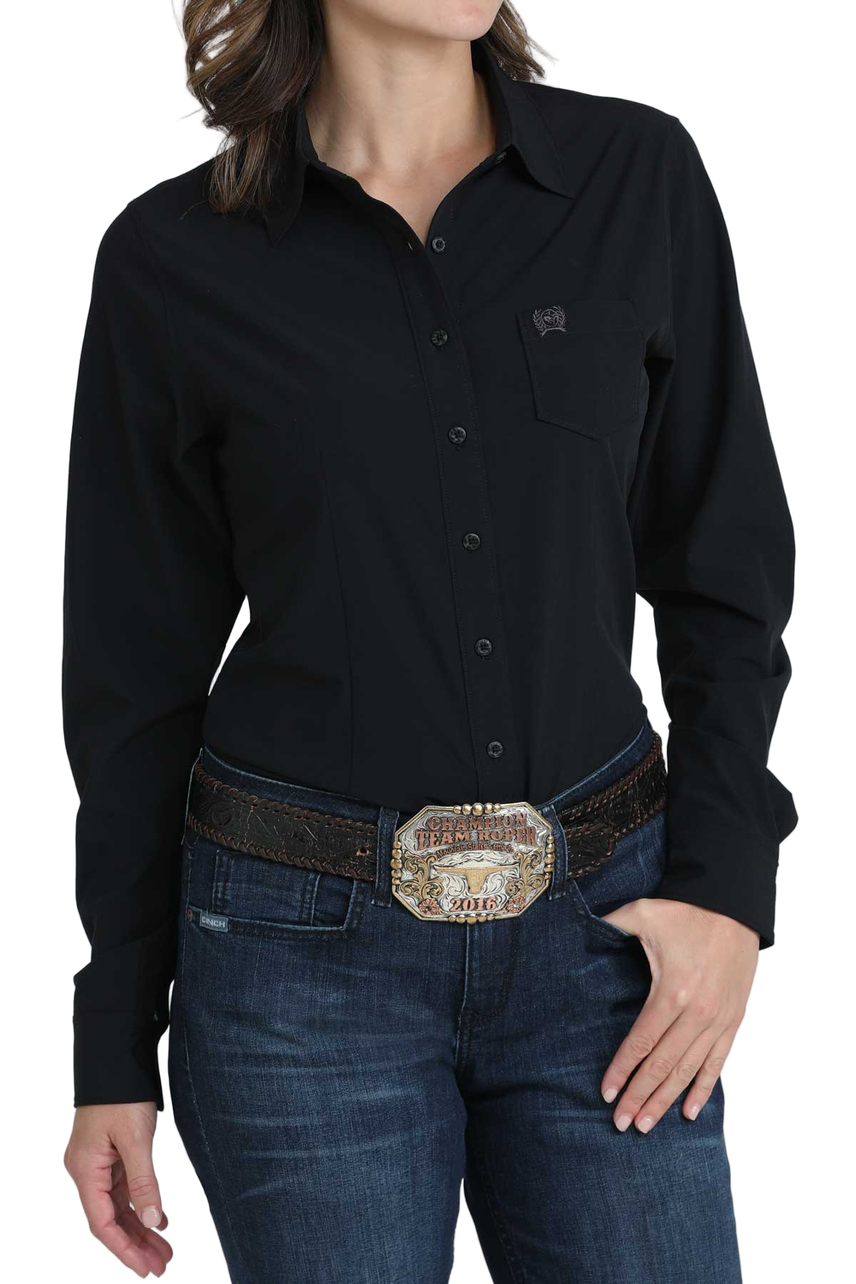 Woman wearing a black long-sleeve button-down shirt, paired with jeans and a large western belt buckle