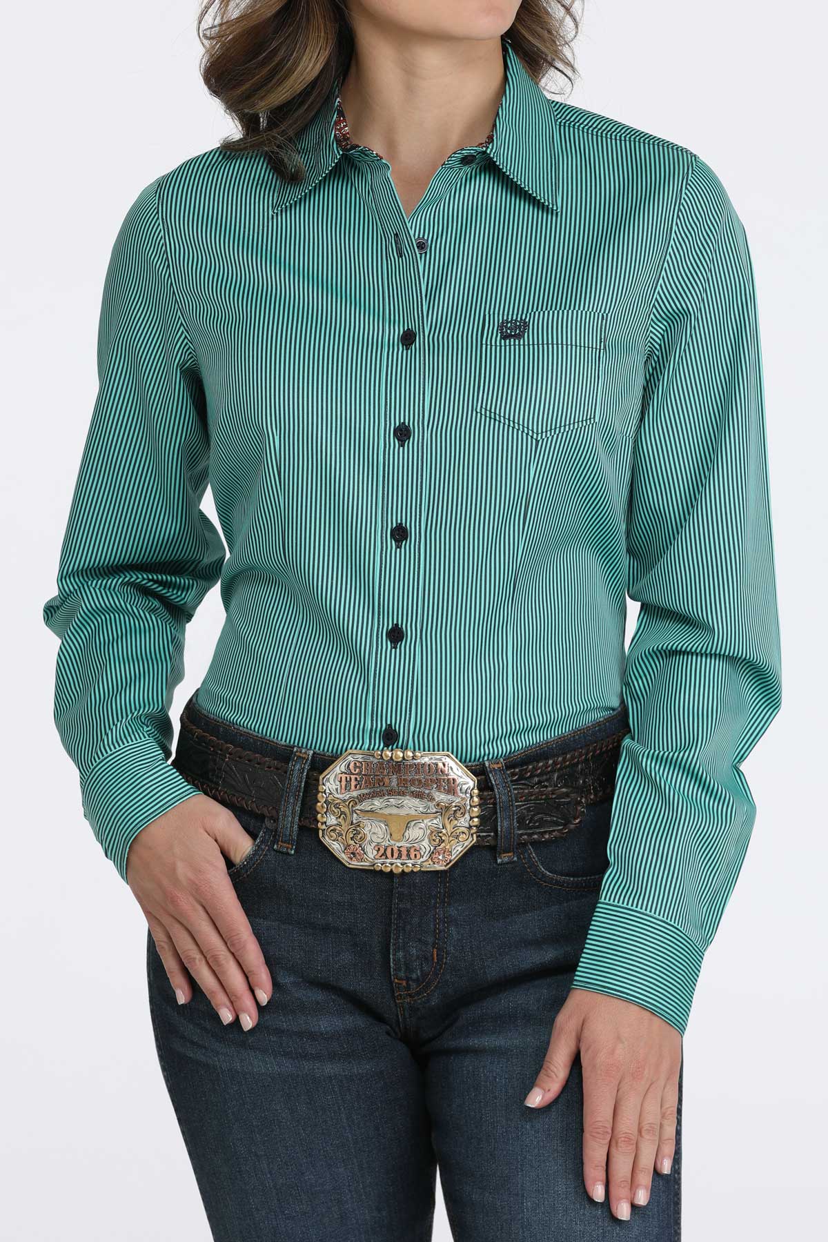 Woman wearing a teal long sleeve button-down with jeans and a belt