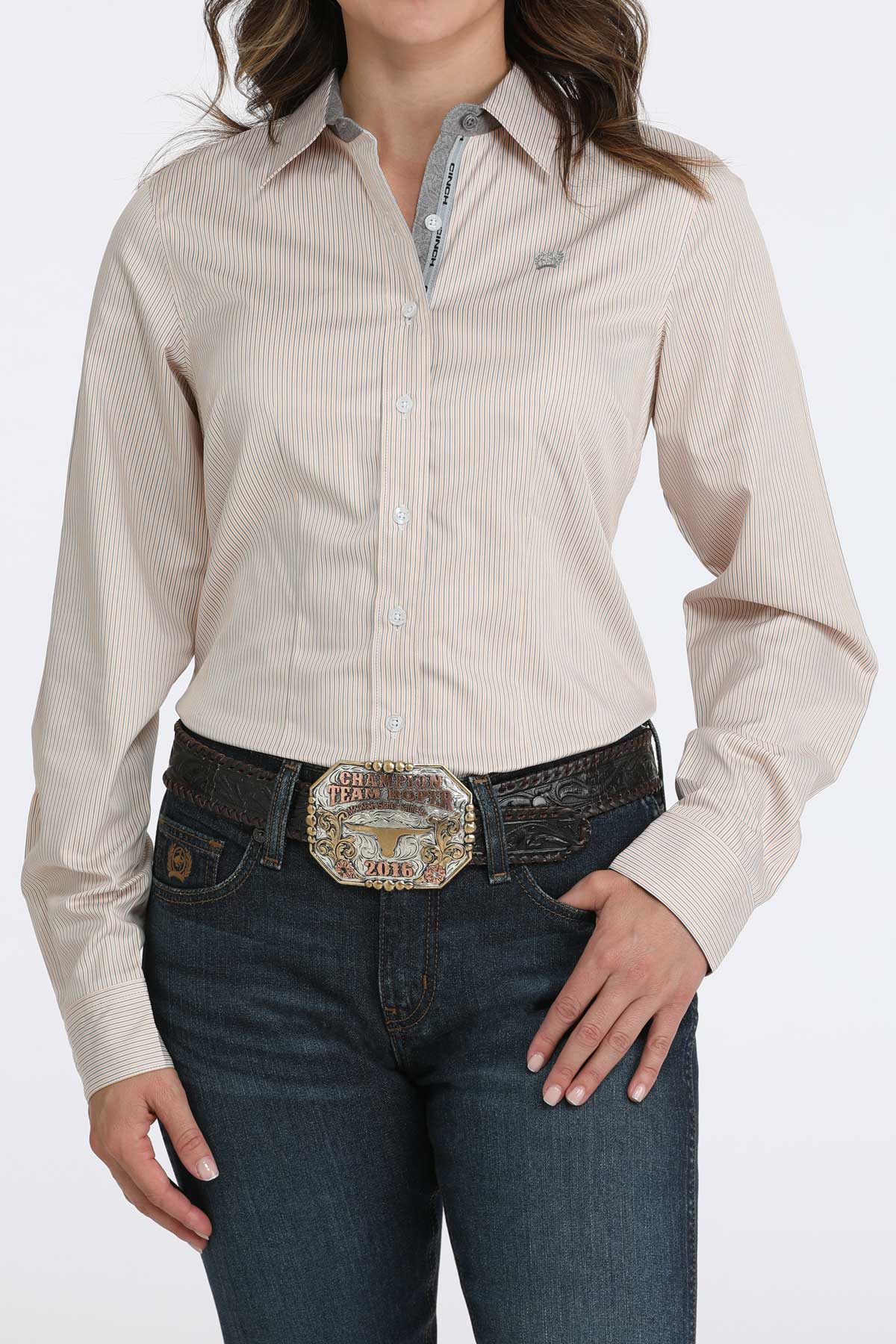 Woman wearing a long sleeve button-down with jeans and a belt