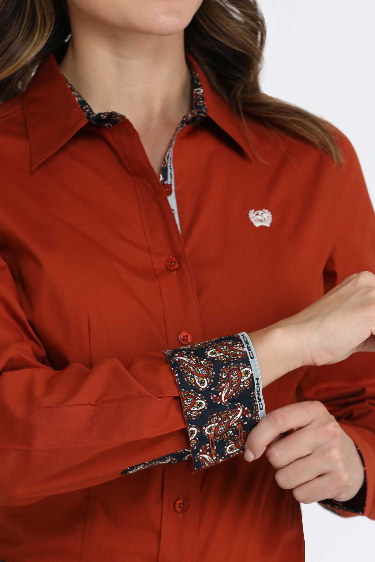 Close-up of a woman wearing a red long sleeve button-down with contrasting patterned cuffs